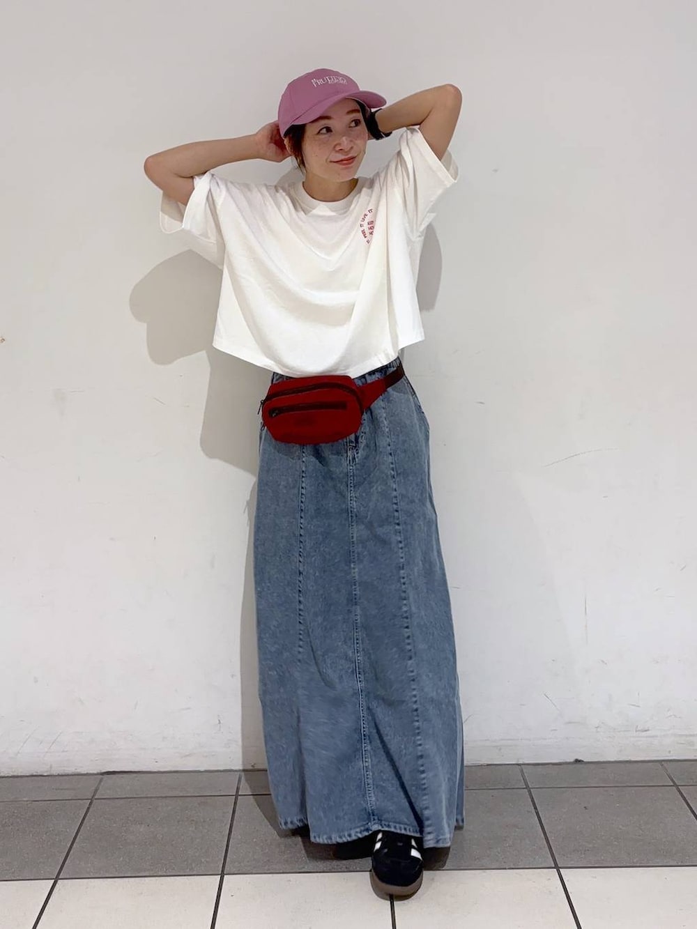 レッド系のボディバッグ/ウエストポーチ、ホワイト系のTシャツ/カットソー、ブルー系のデニムスカートを着用したレディースの夏コーディネートの6枚目の写真
