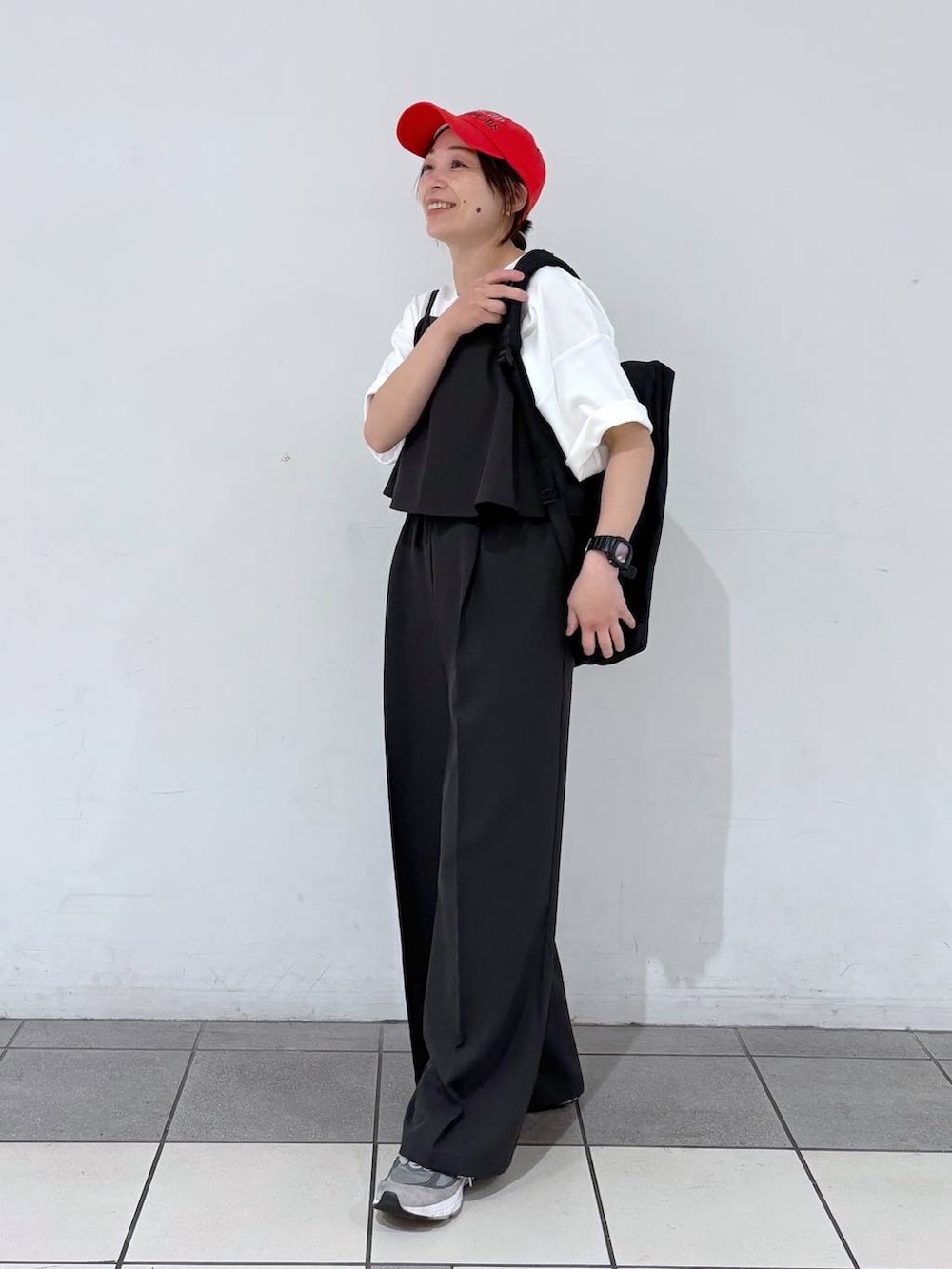 ブラック系のバックパック/リュック、グレー系のサロペット/オーバーオール、ホワイト系のTシャツ/カットソーを着用したレディースの春コーディネートの5枚目の写真