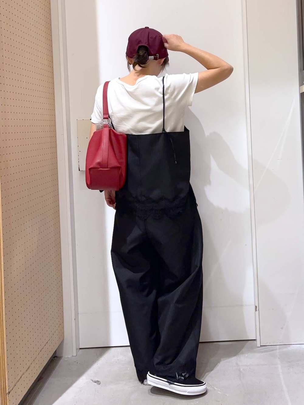 ブラック系のスラックス、ブラック系のキャミソール、レッド系のショルダーバッグを着用したレディースの夏コーディネートの7枚目の写真