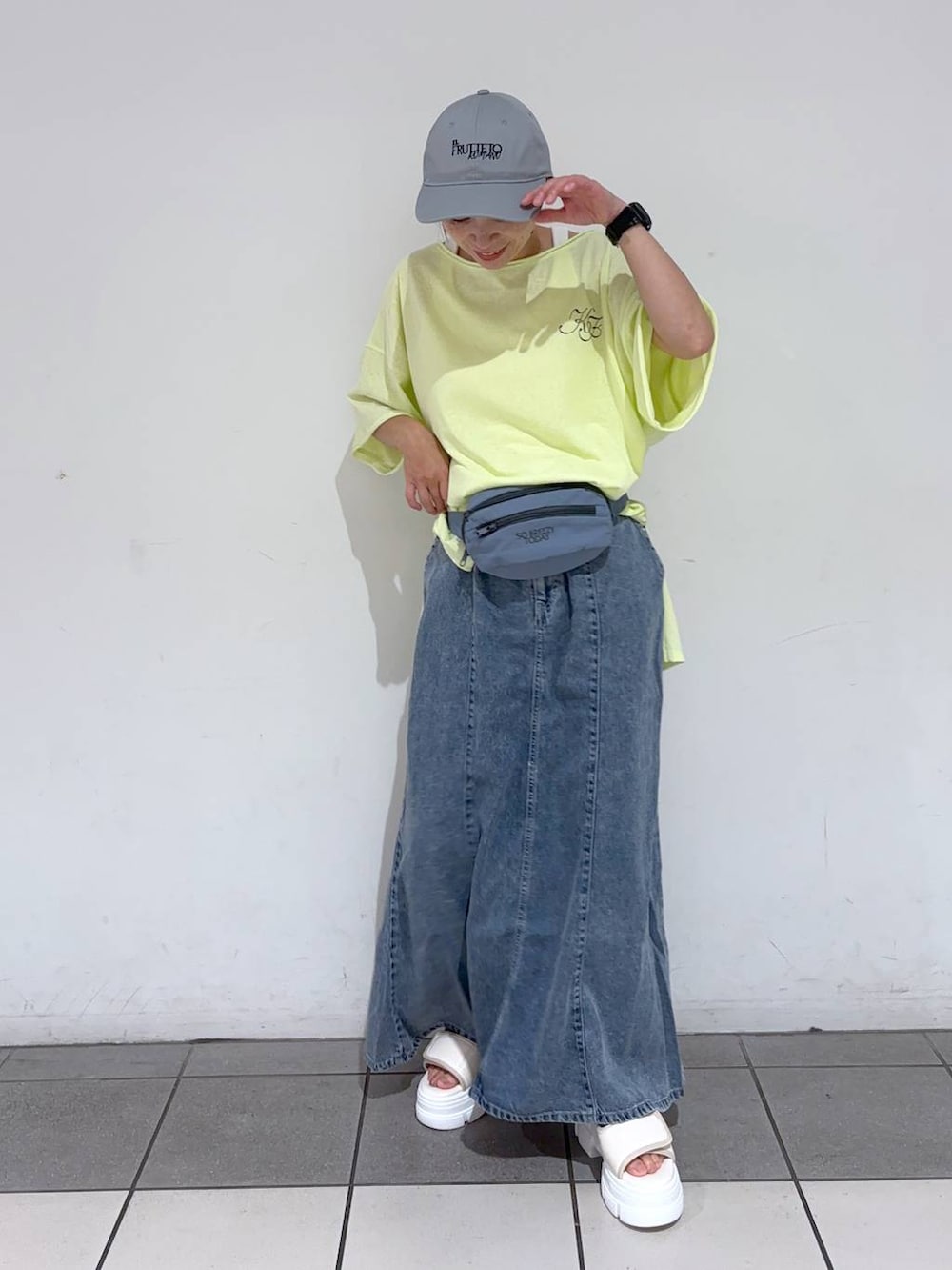 ブルー系のボディバッグ/ウエストポーチ、ホワイト系のサンダル、イエロー系のTシャツ/カットソーを着用したレディースの夏コーディネートの2枚目の写真