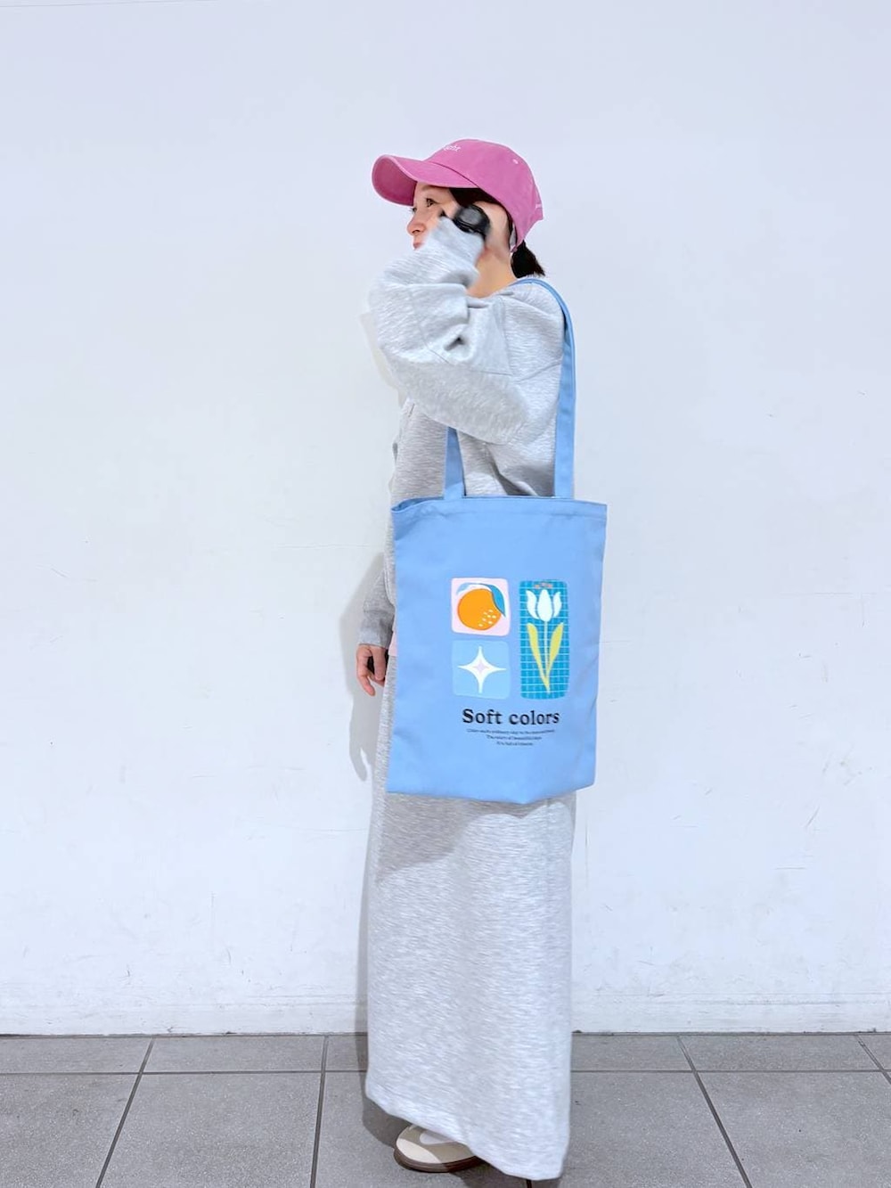 ブルー系のトートバッグ、ホワイト系のスニーカー、グレー系のスウェットを着用したレディースの冬コーディネートの2枚目の写真