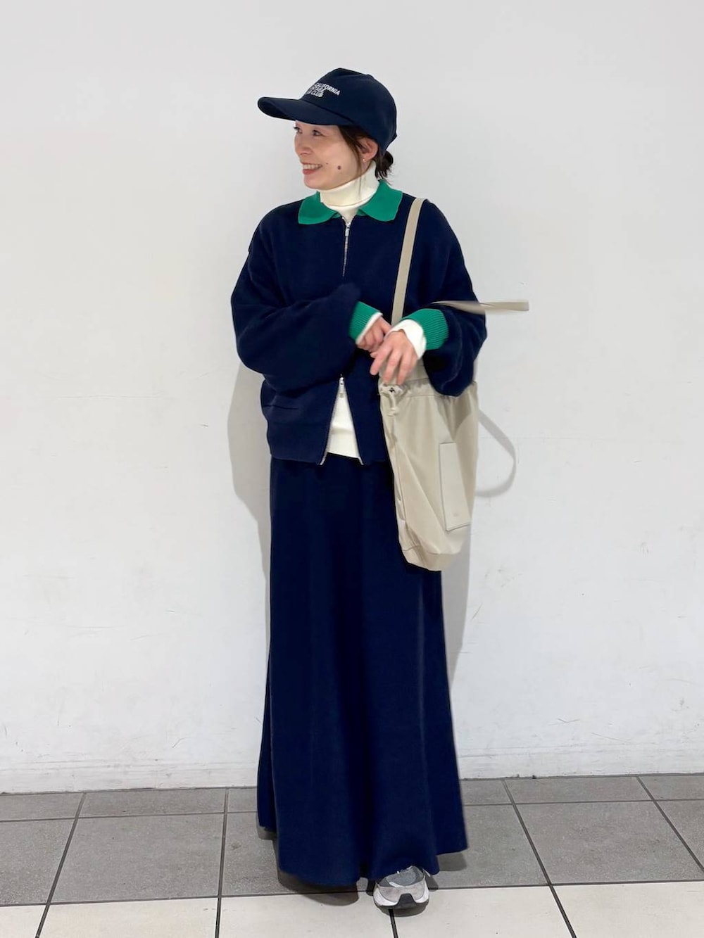 ベージュ系のトートバッグ、ベージュ系のニット/セーター、ブルー系のカーディガン/ボレロを着用したレディースの冬コーディネートの2枚目の写真