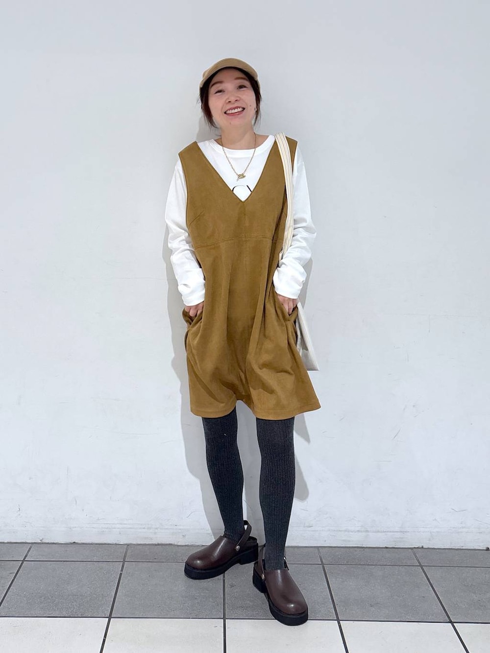 イエロー系のトートバッグ、ホワイト系のTシャツ/カットソー、ホワイト系のスニーカーを着用したレディースの冬コーディネートの5枚目の写真