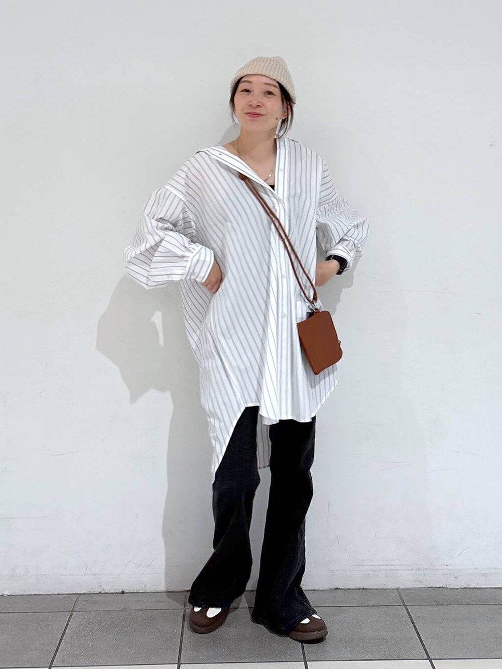 ホワイト系のスニーカー、ブラック系のデニムパンツ、ホワイト系のシャツ/ブラウスを着用したレディースの春コーディネートの5枚目の写真