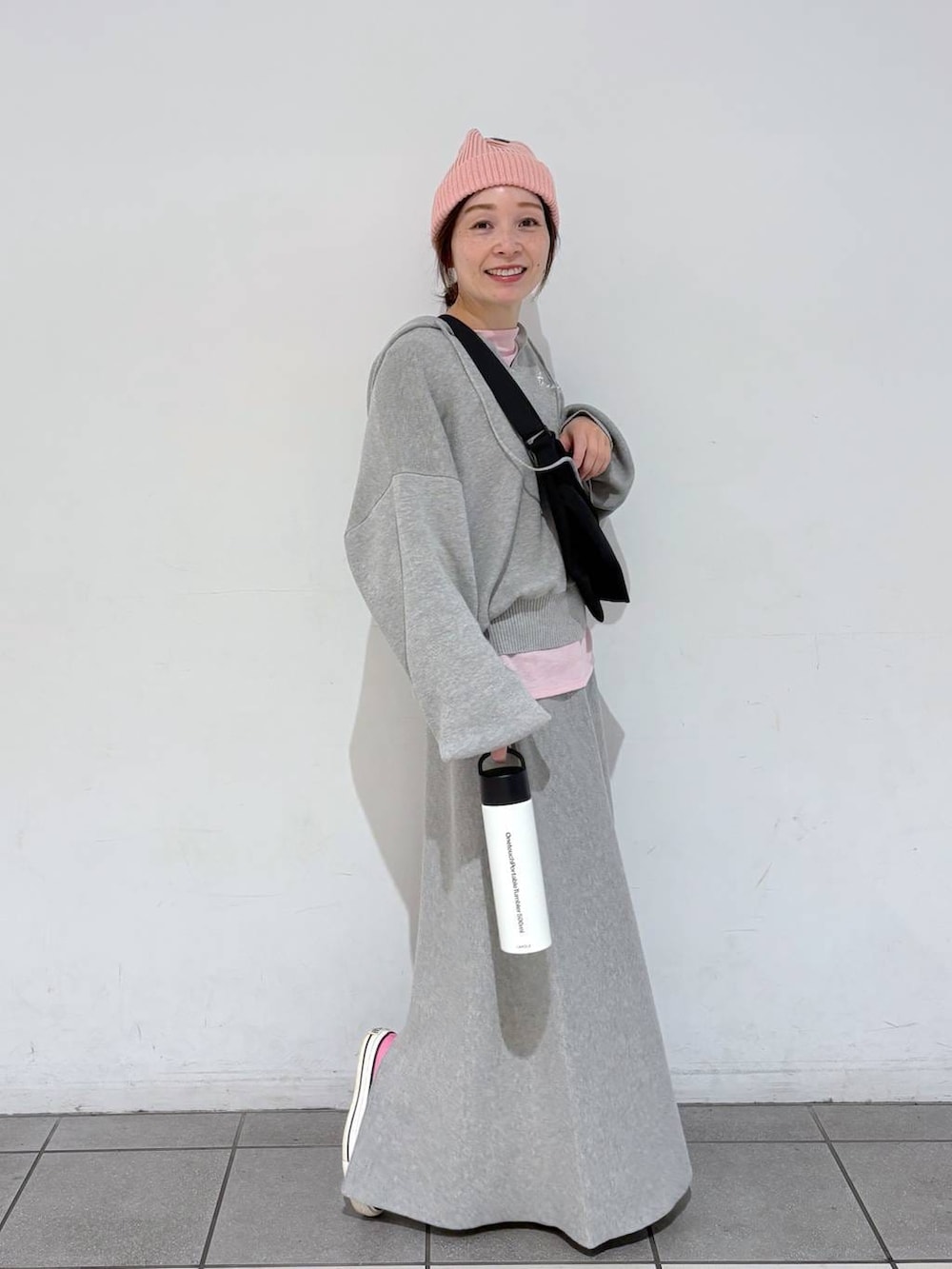ブラック系のショルダーバッグ、グレー系のスカート、ベージュ系の水筒を着用したレディースの冬コーディネートの4枚目の写真