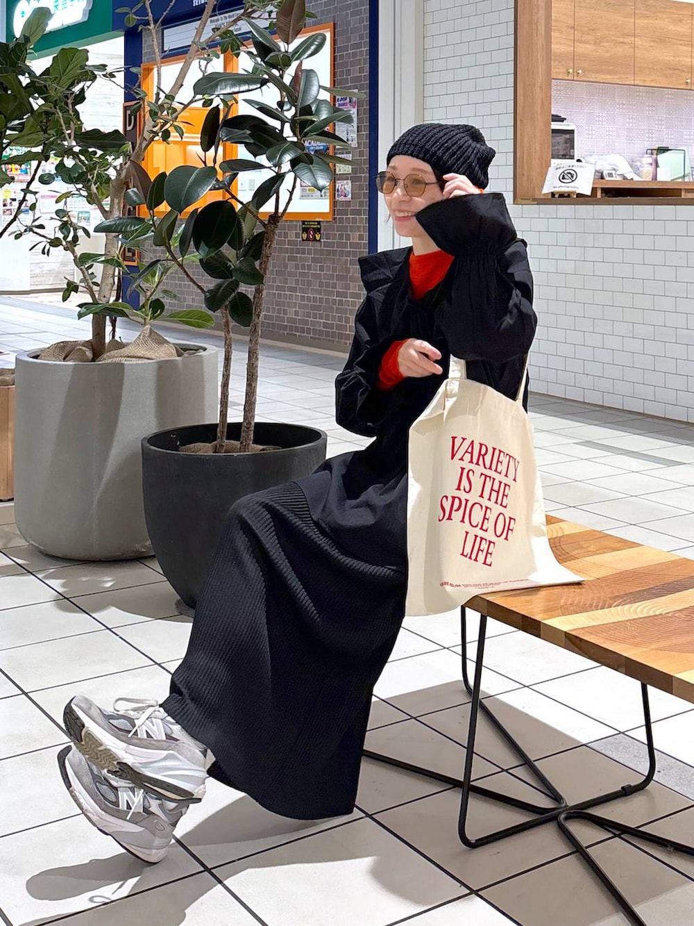 オレンジ系のTシャツ/カットソー、ホワイト系のトートバッグ、ブラック系のシャツ/ブラウスを着用したレディースの冬コーディネートの4枚目の写真