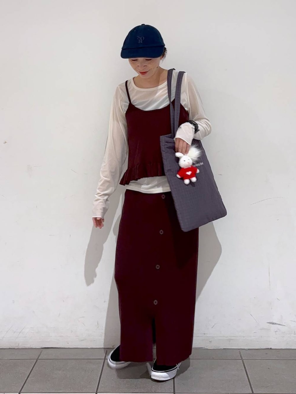 ベージュ系のTシャツ/カットソー、パープル系のトートバッグ、ブラウン系のキャミソールを着用したレディースの秋コーディネートの2枚目の写真