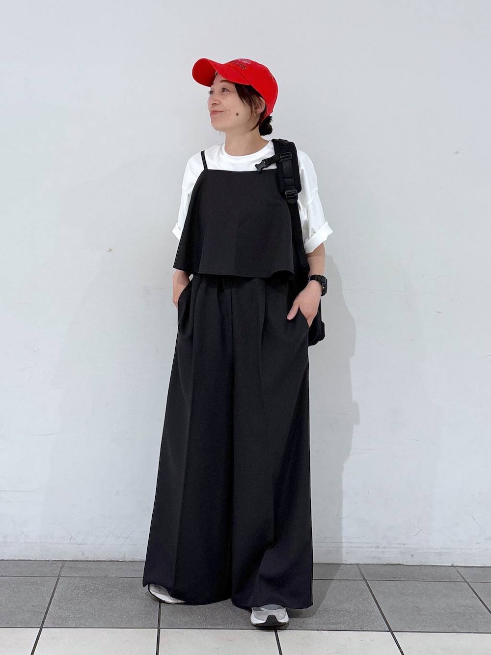 ブラック系のバックパック/リュック、グレー系のサロペット/オーバーオール、ホワイト系のTシャツ/カットソーを着用したレディースの春コーディネートの6枚目の写真