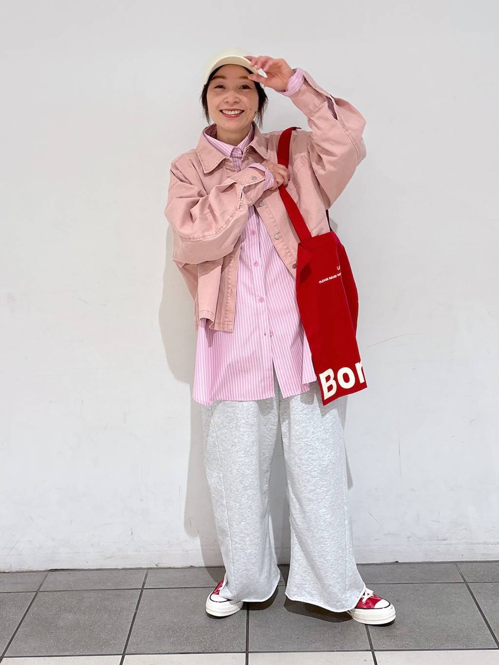 レッド系のトートバッグ、グレー系のその他パンツ、ピンク系のシャツ/ブラウスを着用したレディースの冬コーディネートの2枚目の写真