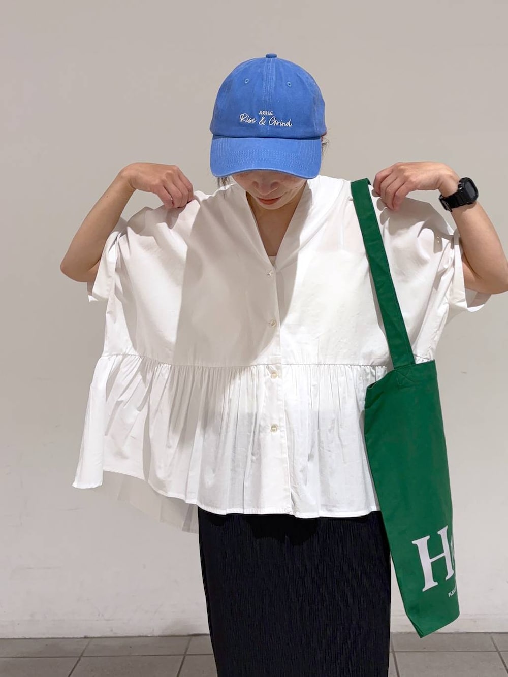 ホワイト系のシャツ/ブラウス、ブラック系のスカート、ブルー系のアウトドアグッズを着用したレディースの夏コーディネートの5枚目の写真