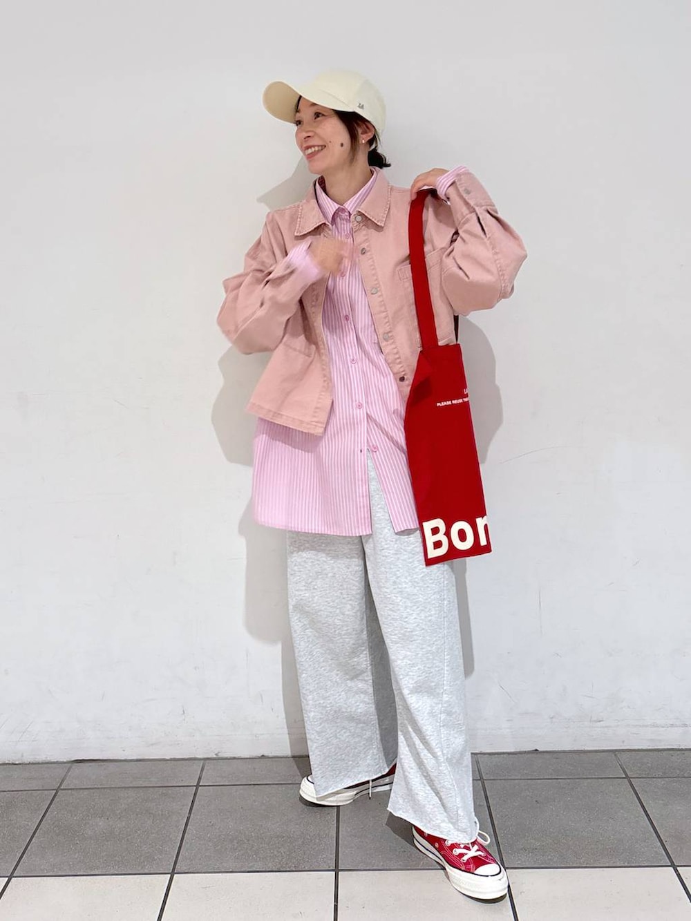 レッド系のトートバッグ、グレー系のその他パンツ、ピンク系のシャツ/ブラウスを着用したレディースの冬コーディネートの3枚目の写真