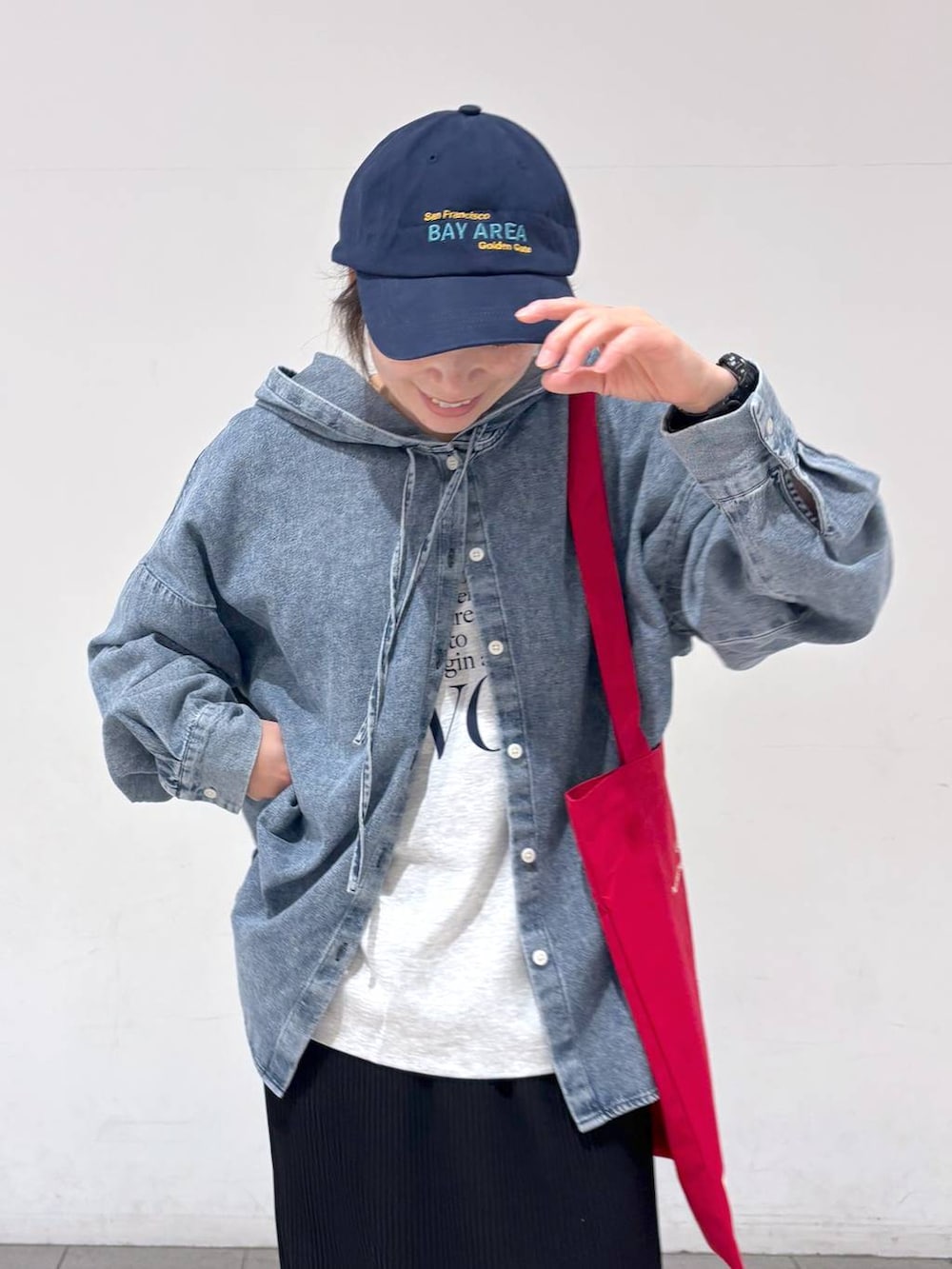 ホワイト系のトートバッグ、ブルー系のその他トップス、ブラック系のスカートを着用したレディースの春コーディネートの5枚目の写真