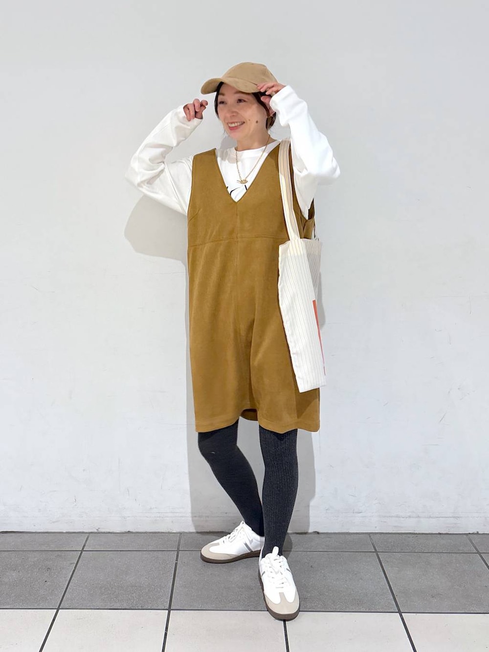 イエロー系のトートバッグ、ホワイト系のTシャツ/カットソー、ホワイト系のスニーカーを着用したレディースの冬コーディネートの3枚目の写真