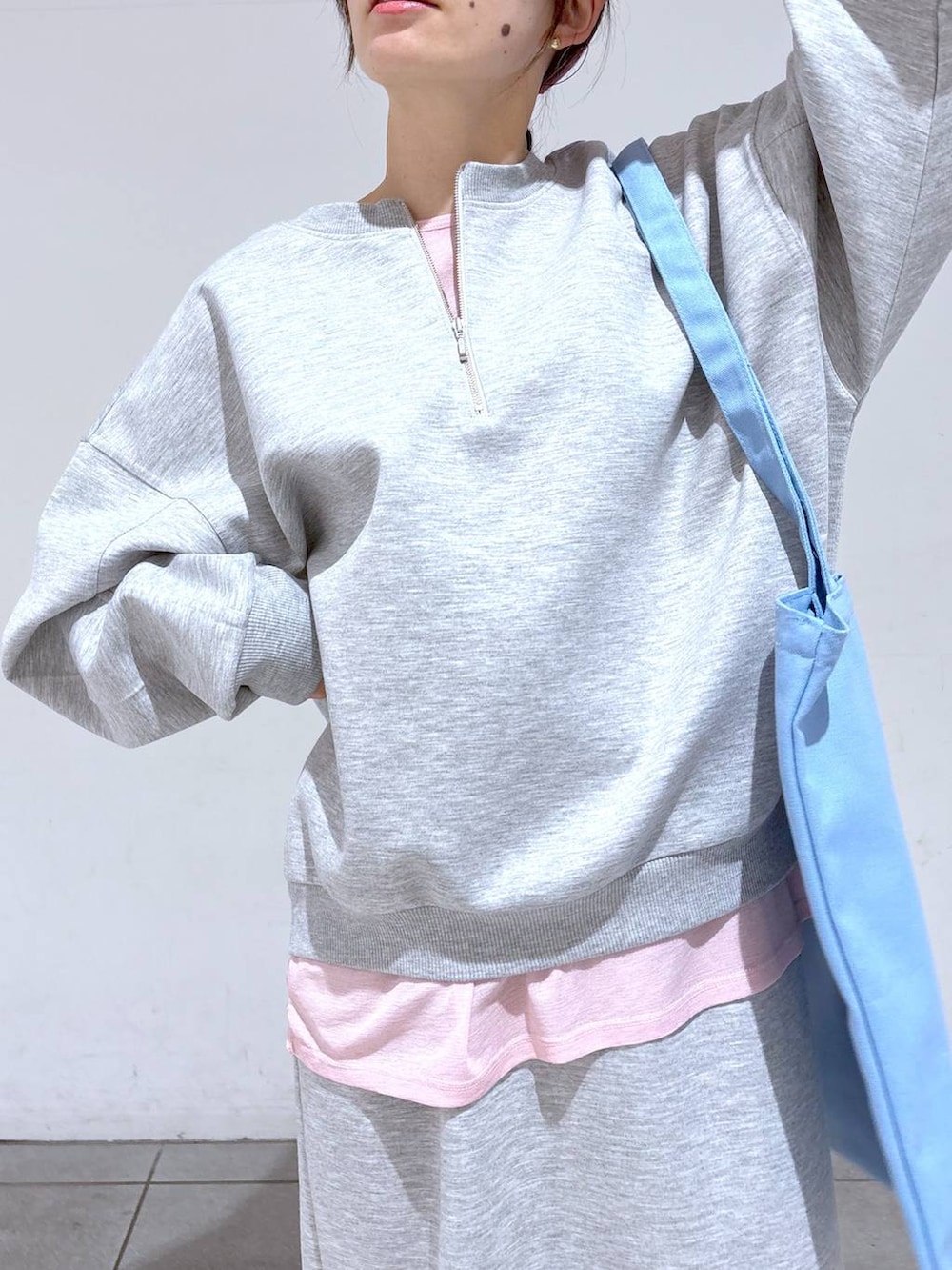 ブルー系のトートバッグ、ホワイト系のスニーカー、グレー系のスウェットを着用したレディースの冬コーディネートの5枚目の写真