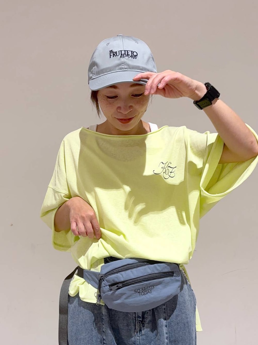 ブルー系のボディバッグ/ウエストポーチ、ホワイト系のサンダル、イエロー系のTシャツ/カットソーを着用したレディースの夏コーディネートの6枚目の写真