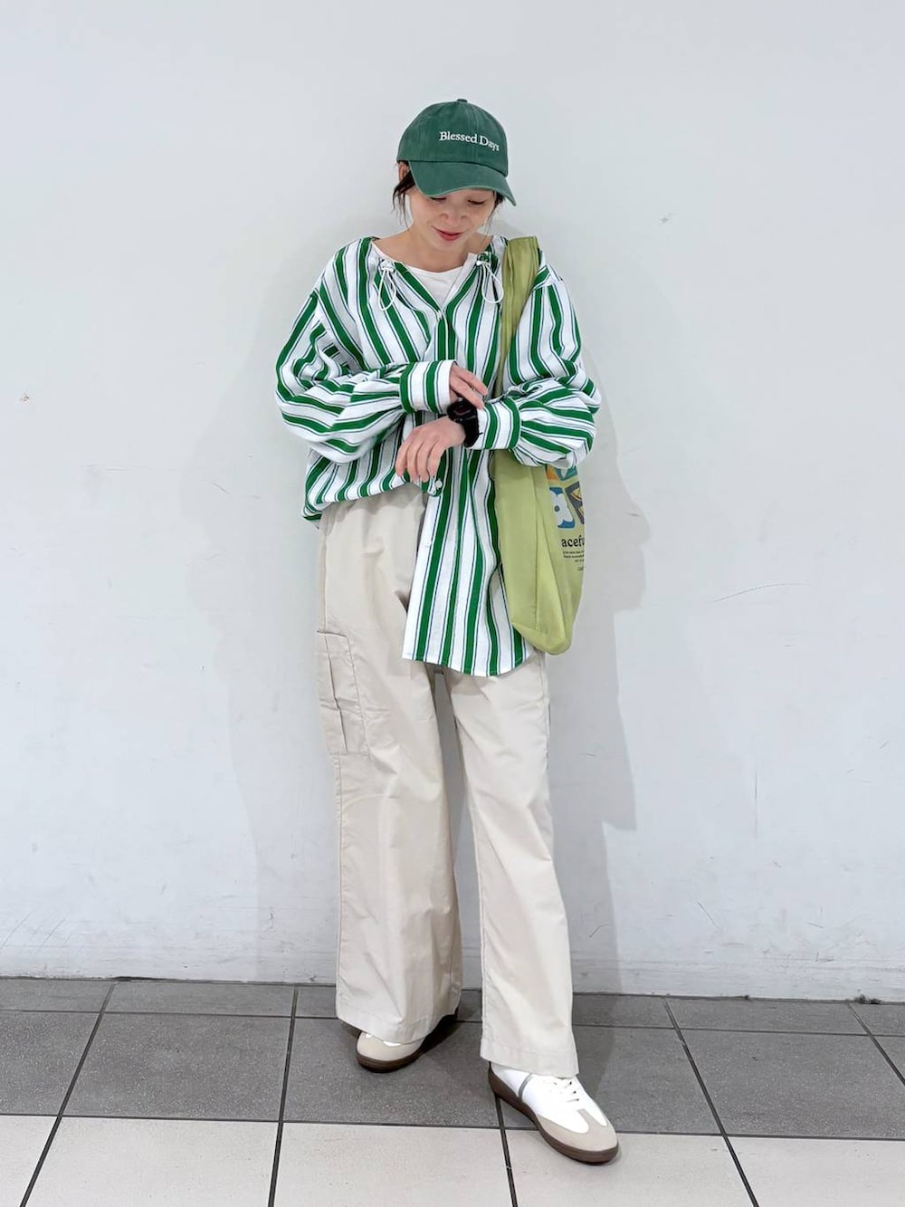 グリーン系のエコバッグ/サブバッグ、ホワイト系のスニーカー、グリーン系のシャツ/ブラウスを着用したレディースの春コーディネートの3枚目の写真