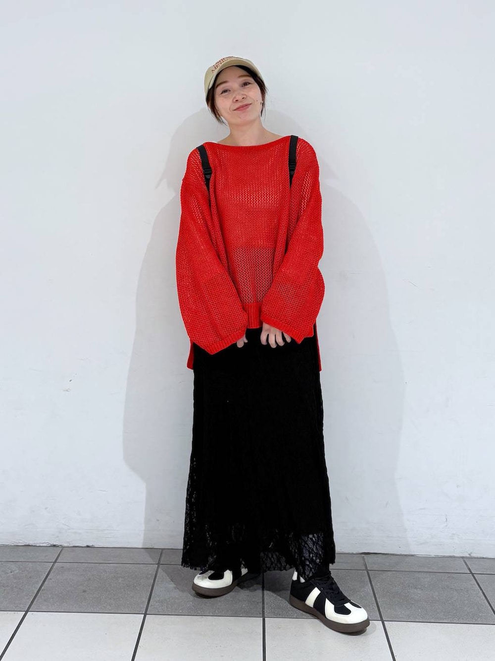 ブラック系のスニーカー、レッド系のニット/セーター、ブラック系のバックパック/リュックを着用したレディースの春コーディネートの5枚目の写真