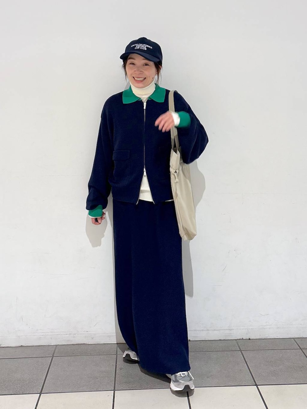 ベージュ系のトートバッグ、ベージュ系のニット/セーター、ブルー系のカーディガン/ボレロを着用したレディースの冬コーディネートの3枚目の写真