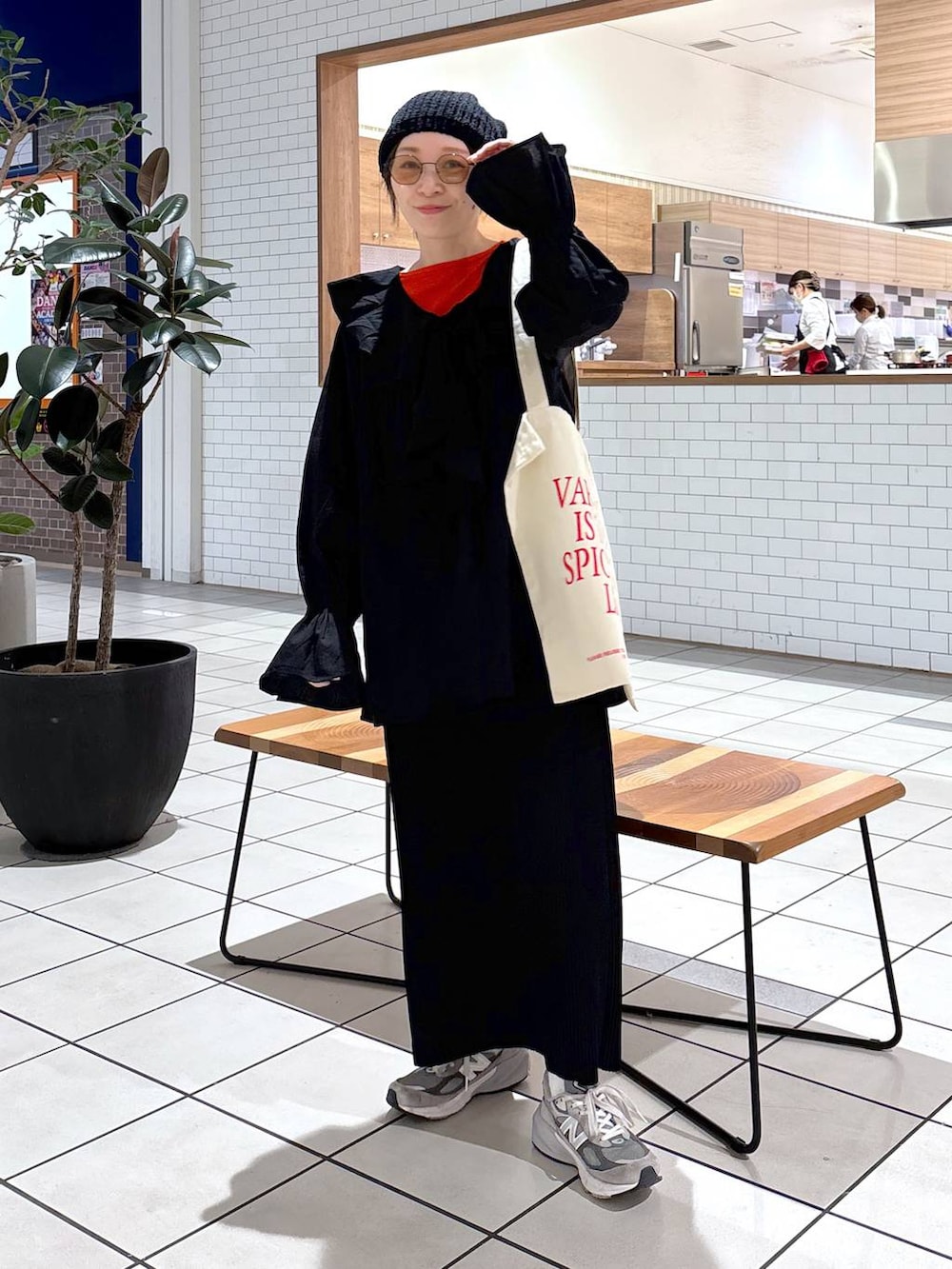 オレンジ系のTシャツ/カットソー、ホワイト系のトートバッグ、ブラック系のシャツ/ブラウスを着用したレディースの冬コーディネートの2枚目の写真