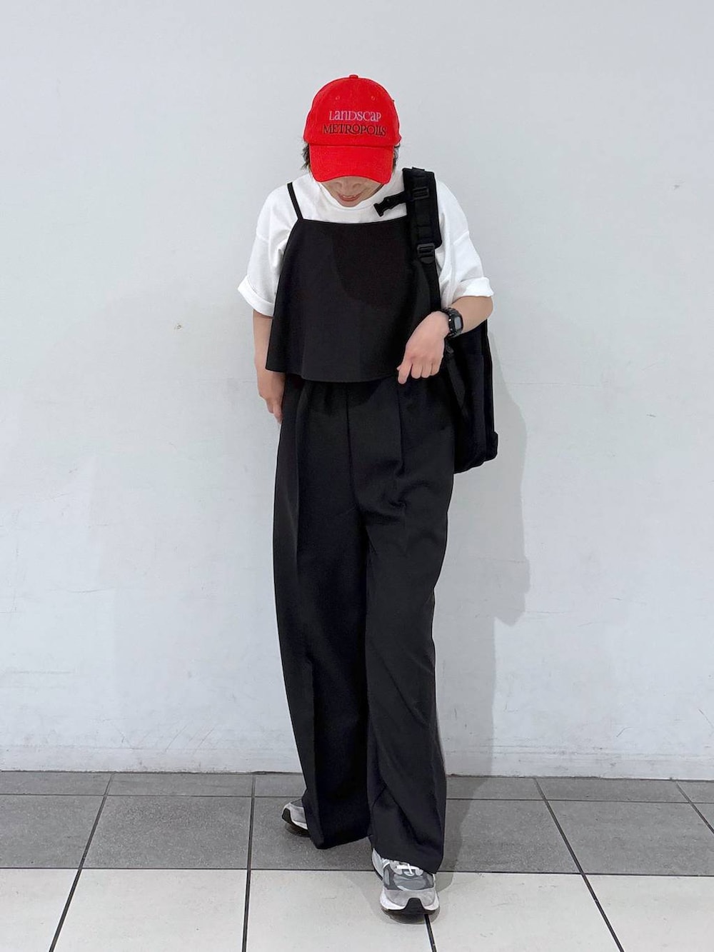 ブラック系のバックパック/リュック、グレー系のサロペット/オーバーオール、ホワイト系のTシャツ/カットソーを着用したレディースの春コーディネートの3枚目の写真