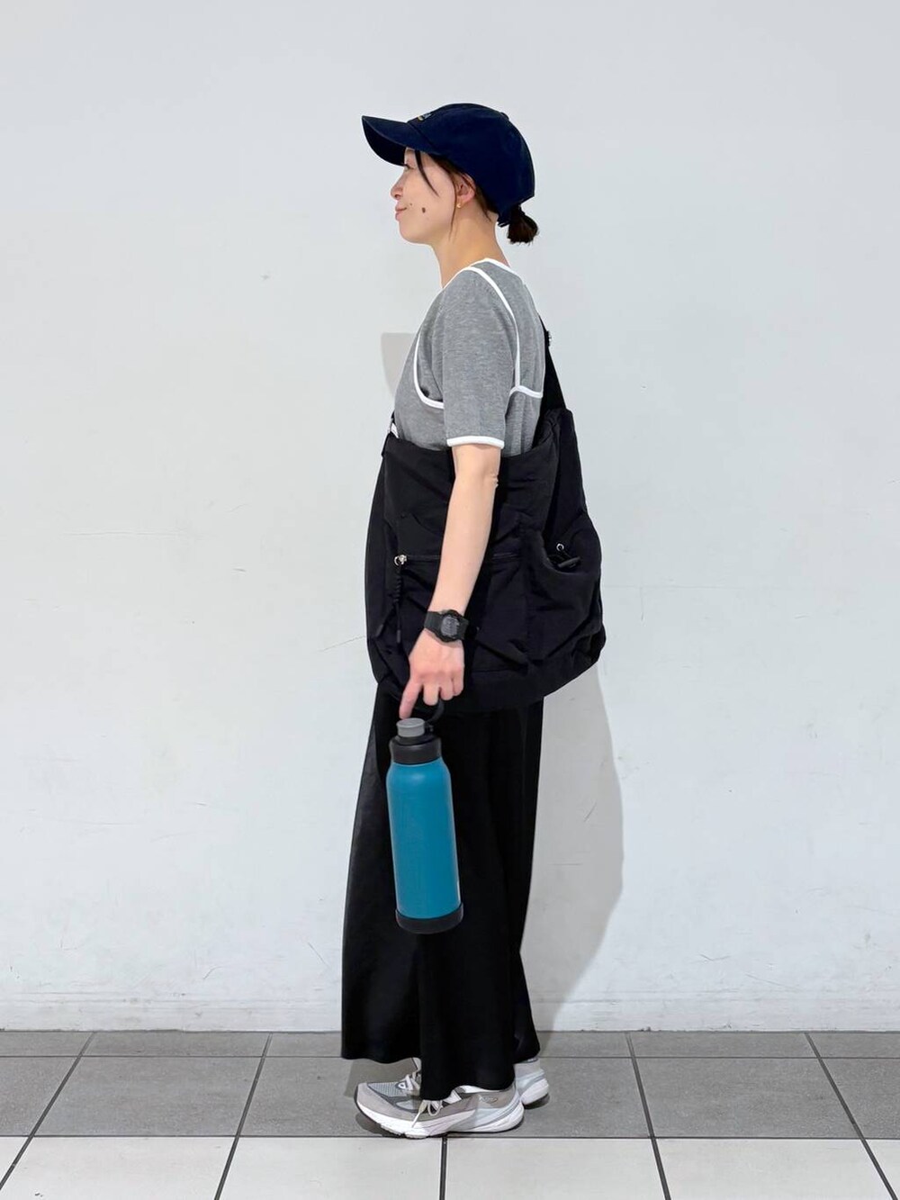 ブラック系のスカート、ブラック系のショルダーバッグ、グレー系のTシャツ/カットソーを着用したレディースの春コーディネートの5枚目の写真