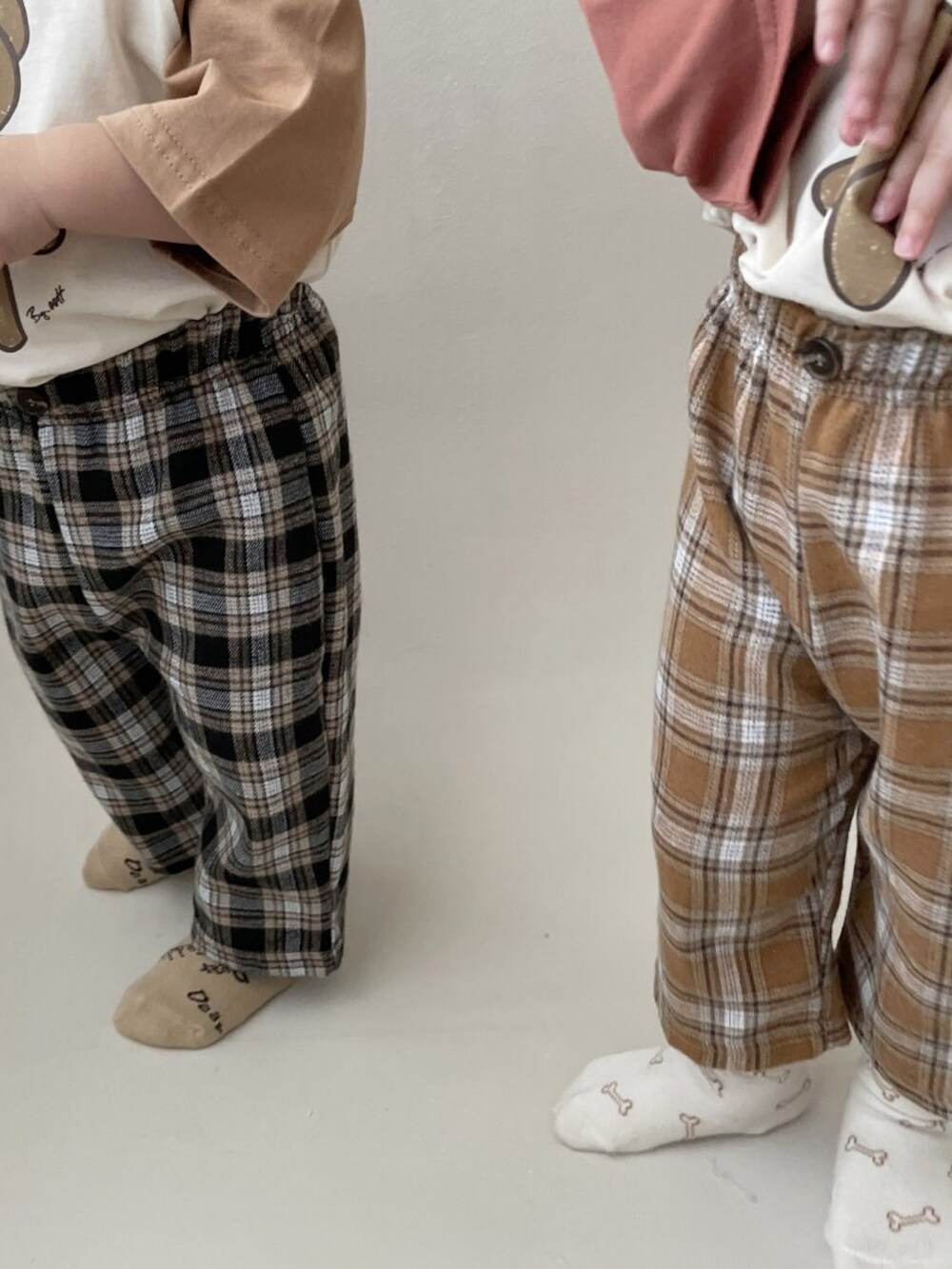 オレンジ系のパンツ、ホワイト系のママ＆ベビーを着用したキッズの秋コーディネートの3枚目の写真