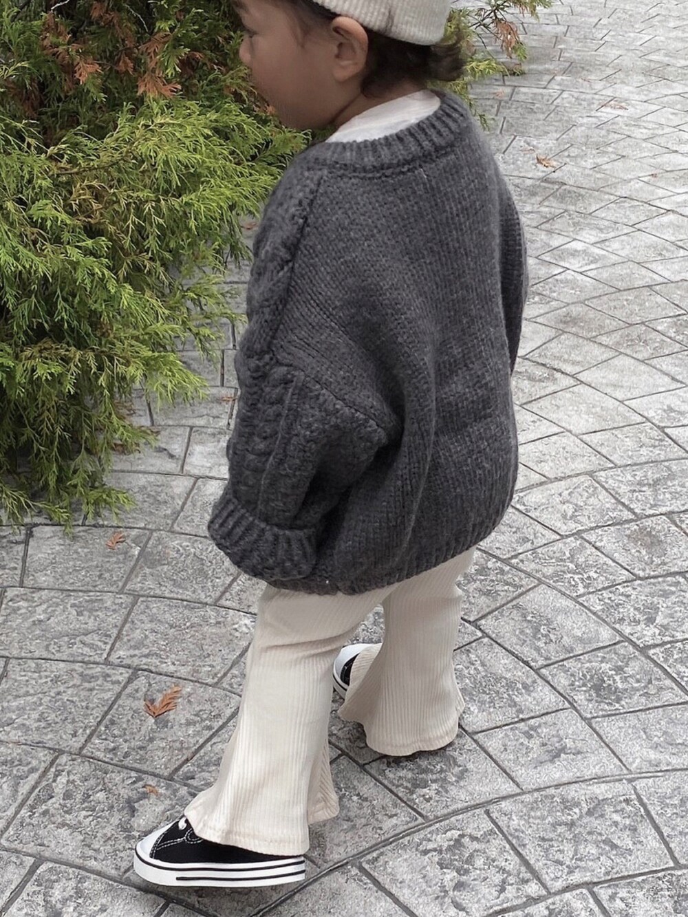 ホワイト系のカーディガン/ボレロ、ブラック系のパンツを着用したキッズの秋コーディネートの2枚目の写真