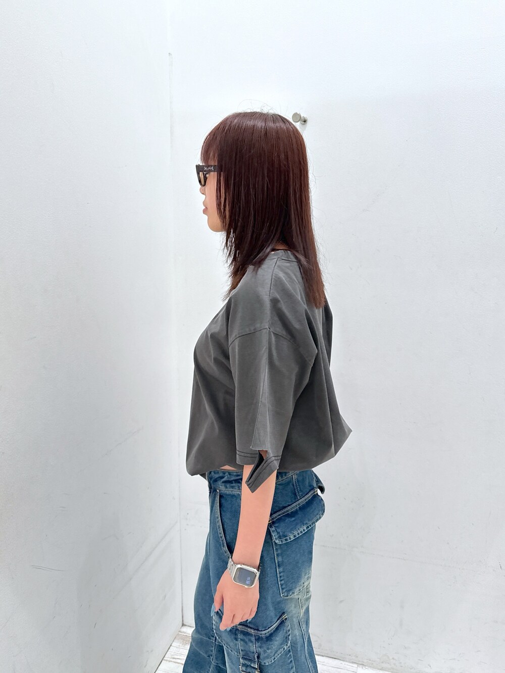 ブルー系のデニムパンツ、ブラック系のTシャツ/カットソー、ブラウン系のサングラスを着用したレディースの夏コーディネートの5枚目の写真