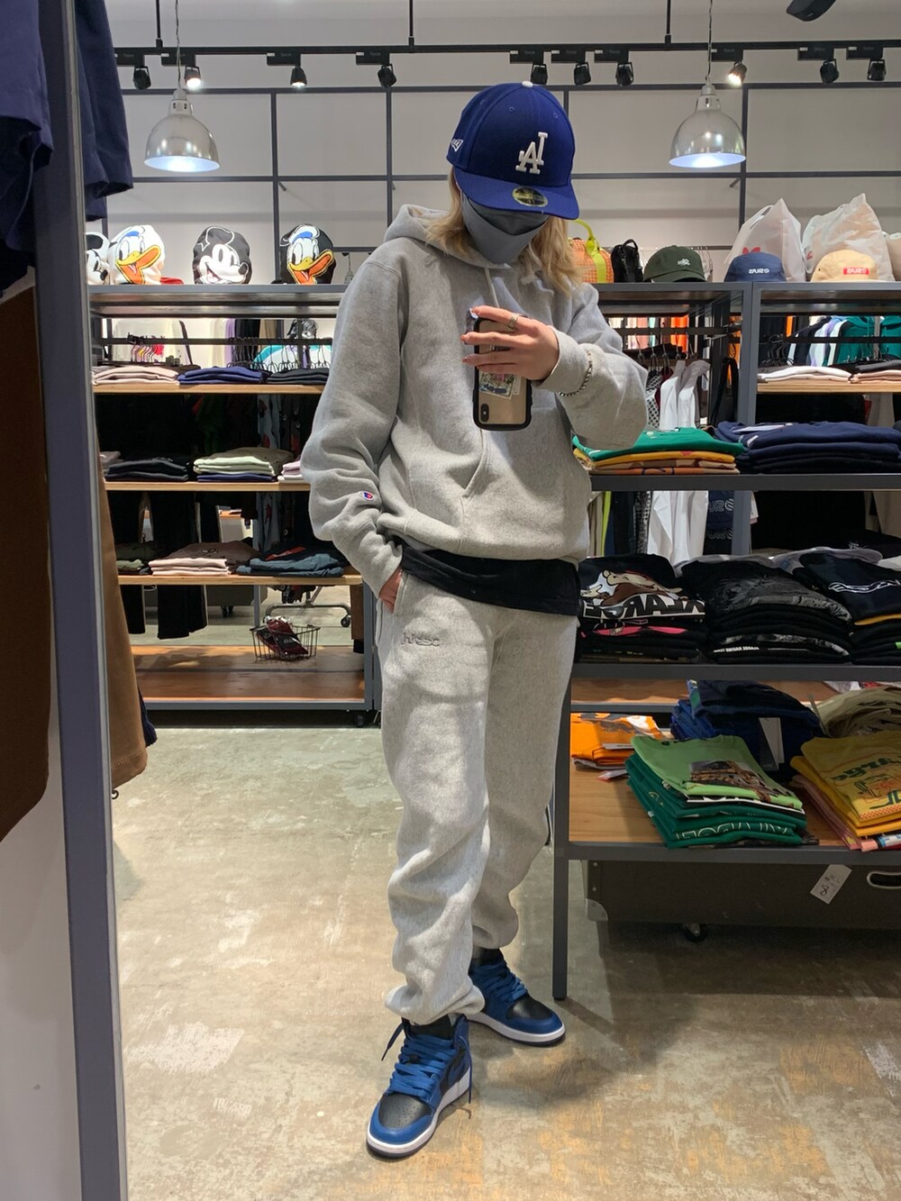 グレー系のパーカー、グレー系のスウェットパンツ、ブルー系のキャップを着用したレディースの春コーディネートの2枚目の写真