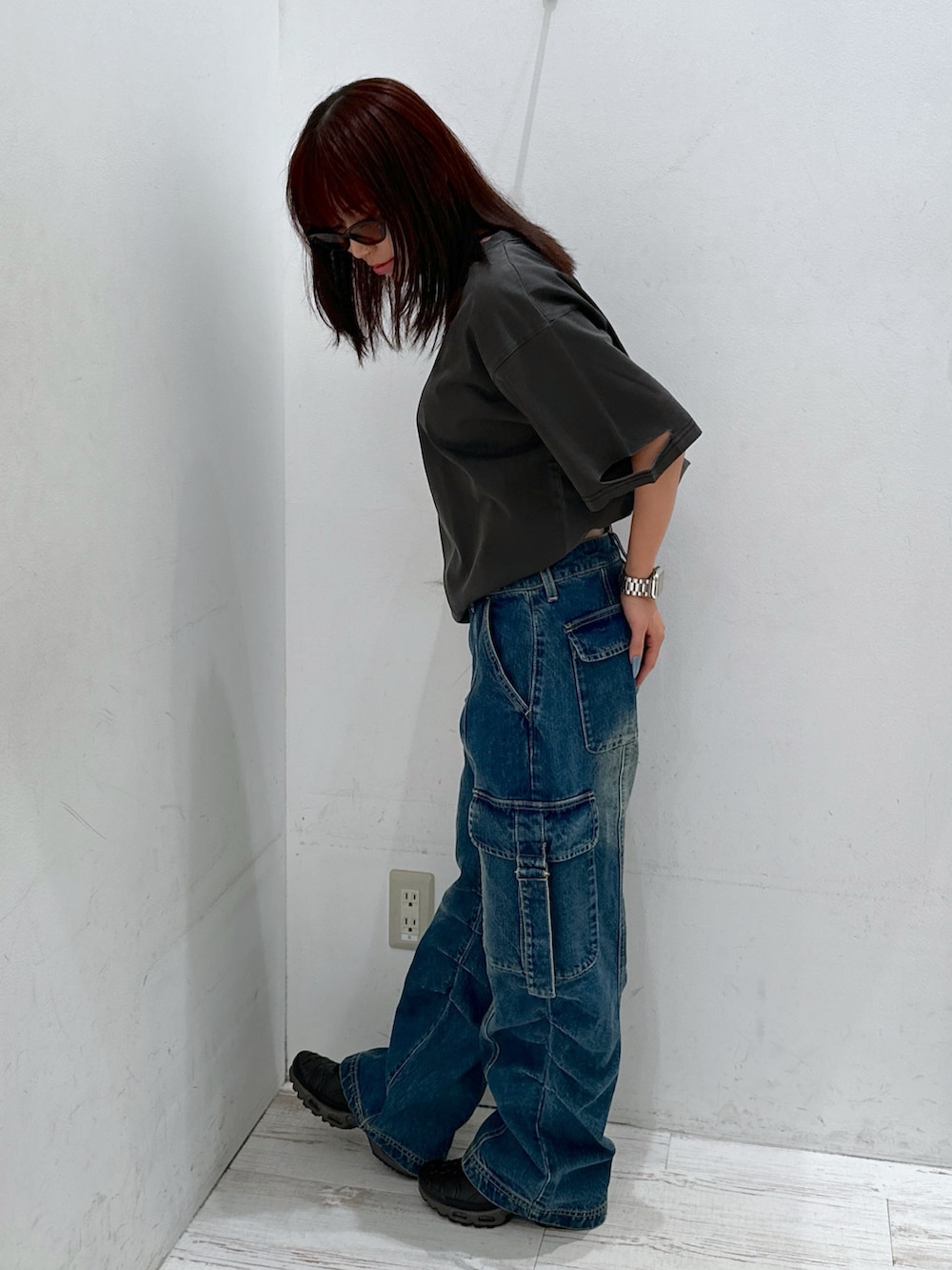 ブルー系のデニムパンツ、ブラック系のTシャツ/カットソー、ブラウン系のサングラスを着用したレディースの夏コーディネートの2枚目の写真