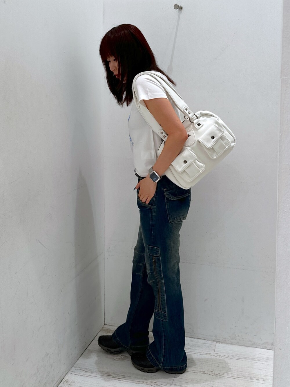 ブルー系のデニムパンツ、ホワイト系のTシャツ/カットソー、ホワイト系のハンドバッグを着用したレディースの夏コーディネートの2枚目の写真