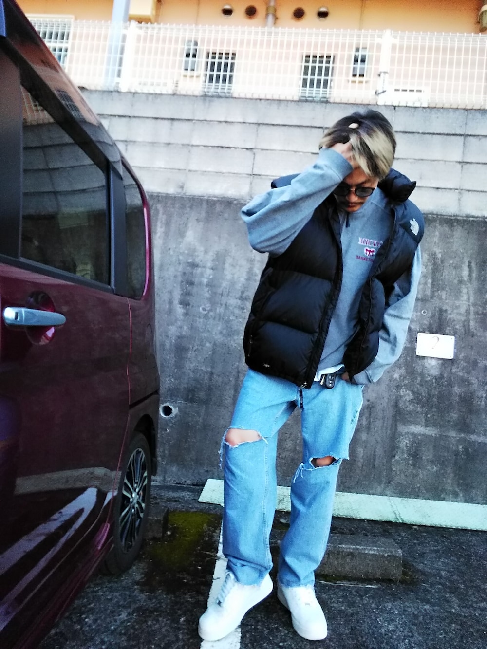 グレー系のスウェット、ブルー系のデニムパンツ、ホワイト系のスニーカーを着用したメンズの冬コーディネートの2枚目の写真