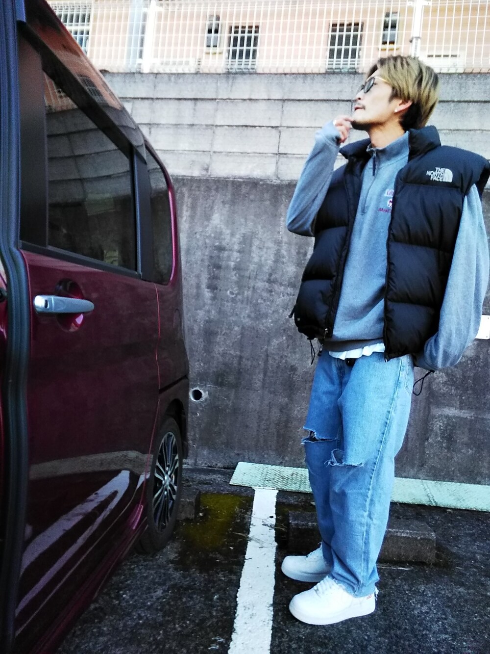 グレー系のスウェット、ブルー系のデニムパンツ、ホワイト系のスニーカーを着用したメンズの冬コーディネートの3枚目の写真