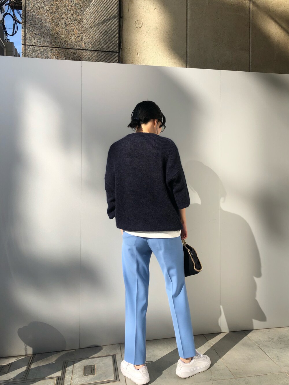 ブルー系のニット/セーター、ブルー系のパンツ、ブラック系のショルダーバッグを着用したレディースの秋コーディネートの3枚目の写真