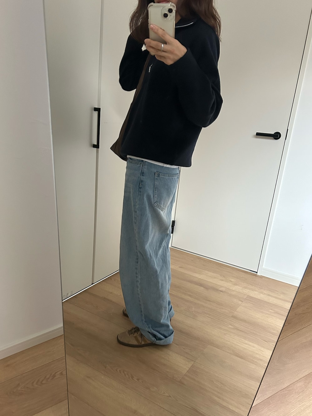 ブルー系のニット/セーター、ブルー系のデニムパンツ、ベージュ系のスニーカーを着用したレディースの冬コーディネートの2枚目の写真