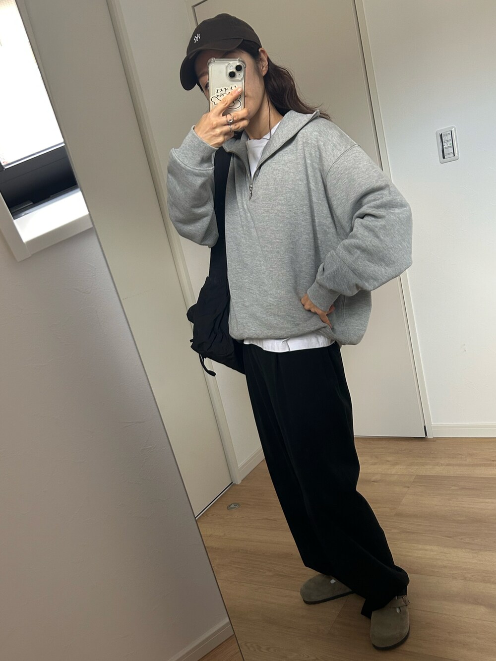 グレー系のスウェット、ベージュ系のサンダル、ブラウン系のキャップを着用したレディースの冬コーディネートの3枚目の写真