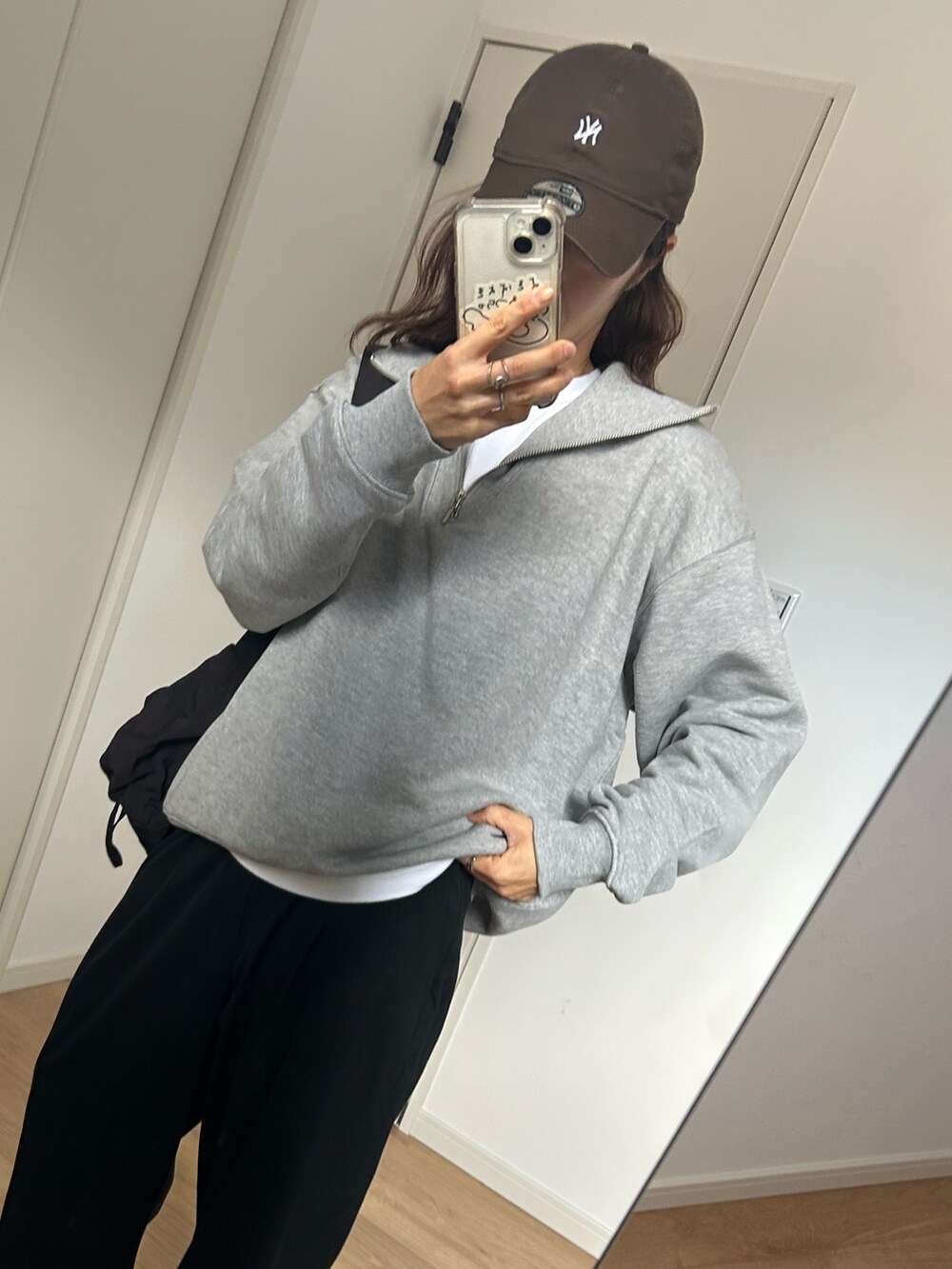 グレー系のスウェット、ベージュ系のサンダル、ブラウン系のキャップを着用したレディースの冬コーディネートの4枚目の写真