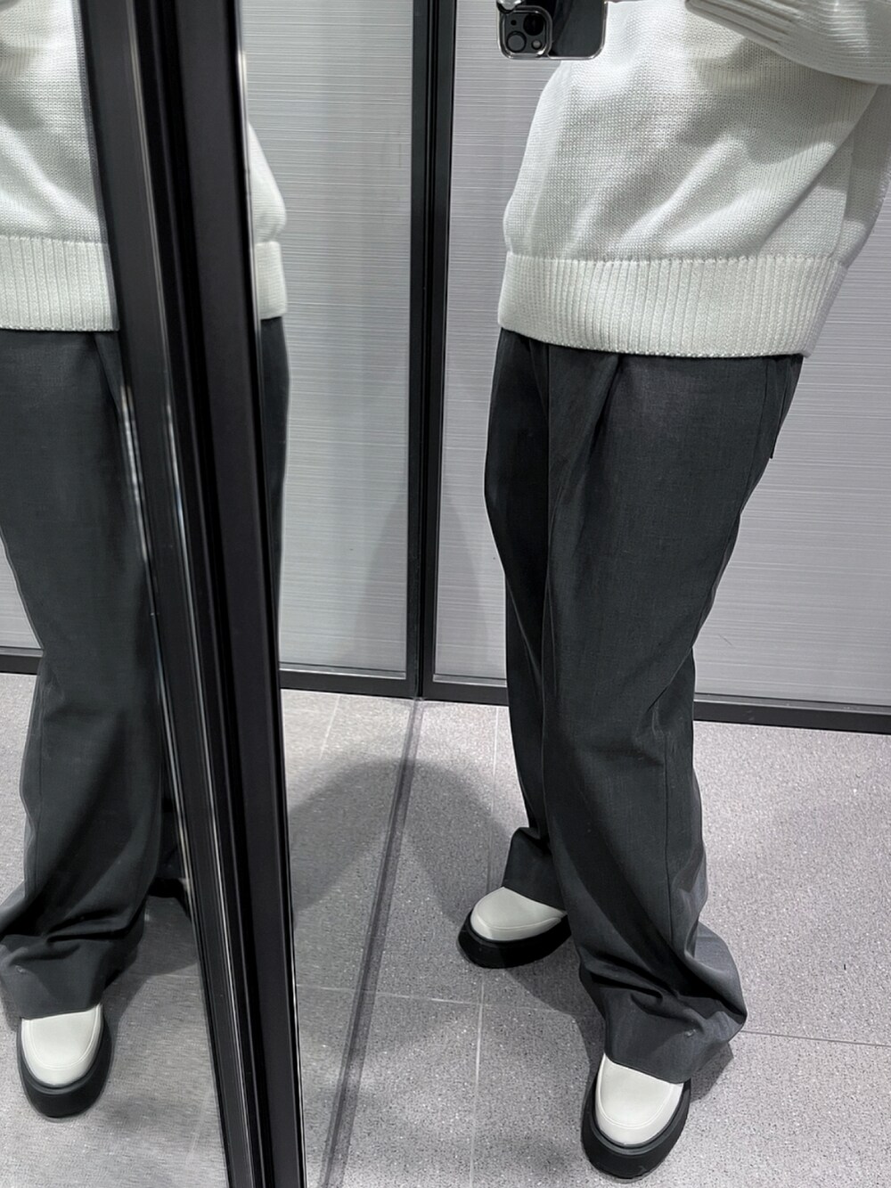 ホワイト系のニット/セーター、グレー系のパンツ、ホワイト系のシューズを着用したレディースの春コーディネートの2枚目の写真