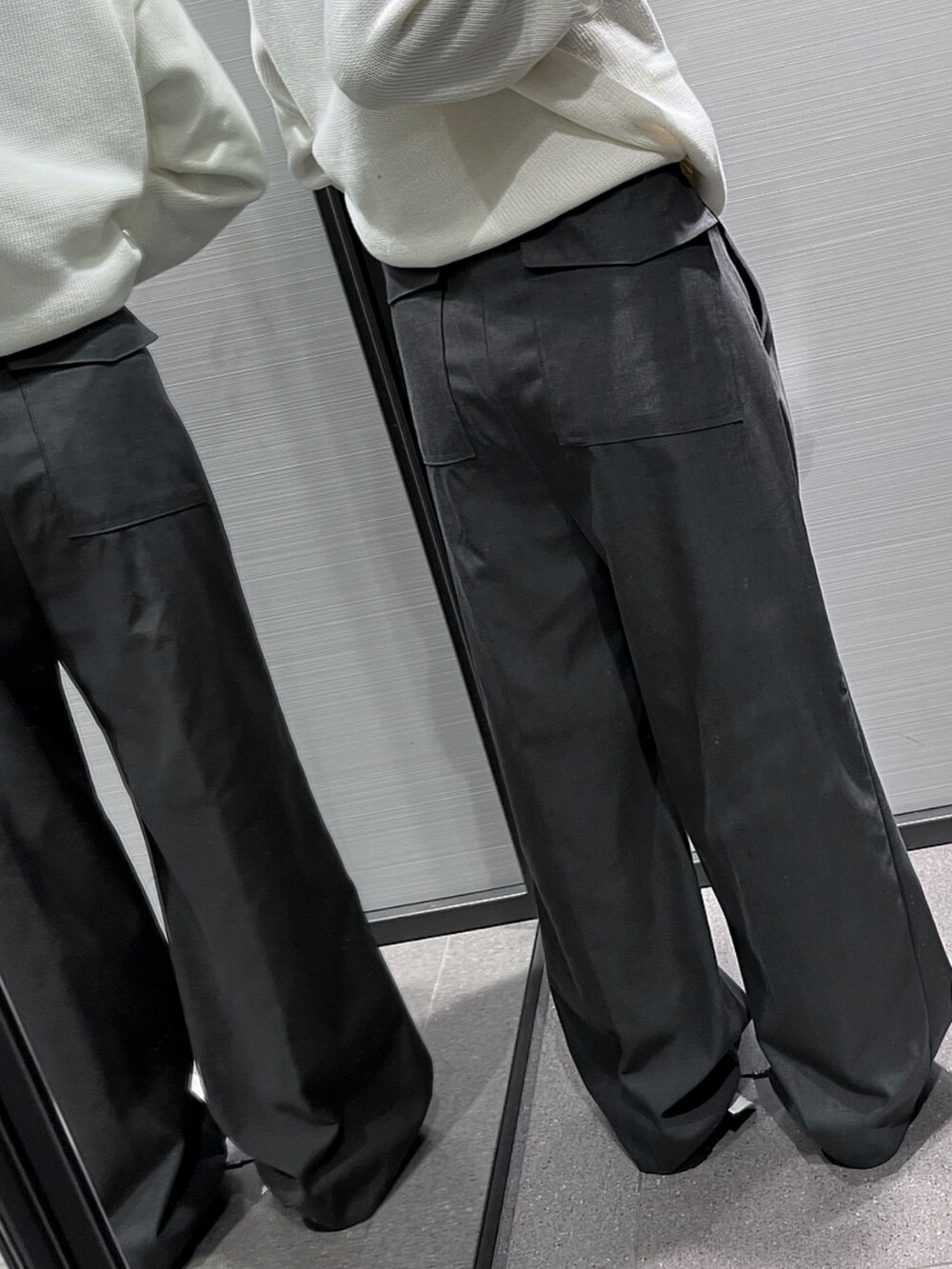 ホワイト系のニット/セーター、グレー系のパンツ、ホワイト系のシューズを着用したレディースの春コーディネートの3枚目の写真