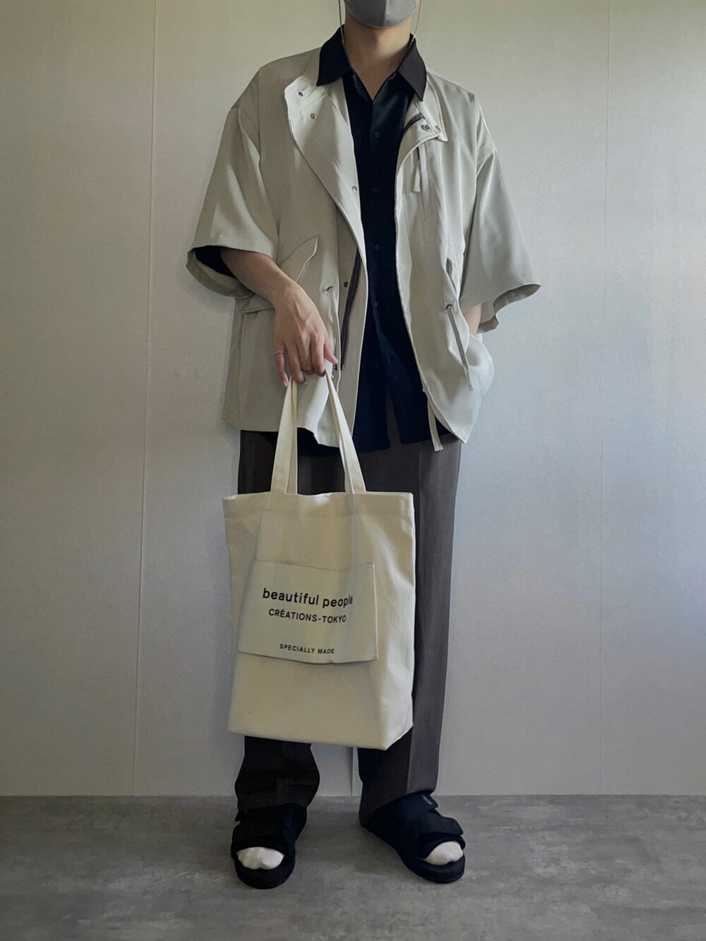 ホワイト系のトートバッグ、ベージュ系のシャツ/ブラウス、ブラック系のシャツ/ブラウスを着用したメンズの春コーディネートの2枚目の写真