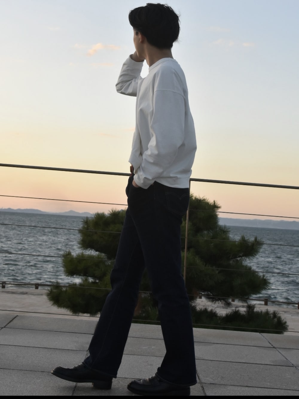 ホワイト系のTシャツ/カットソー、ブルー系のパンツ、ブラック系のローファーを着用したメンズの冬コーディネートの2枚目の写真