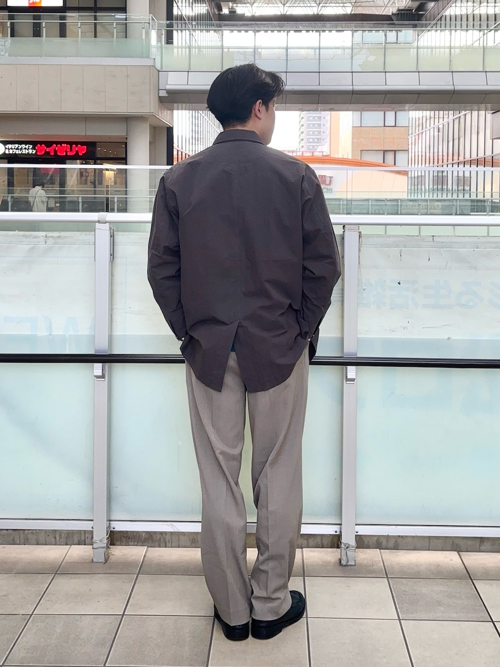 グレー系のカバーオール、グリーン系のニット/セーター、ベージュ系のその他パンツを着用したメンズの春コーディネートの3枚目の写真