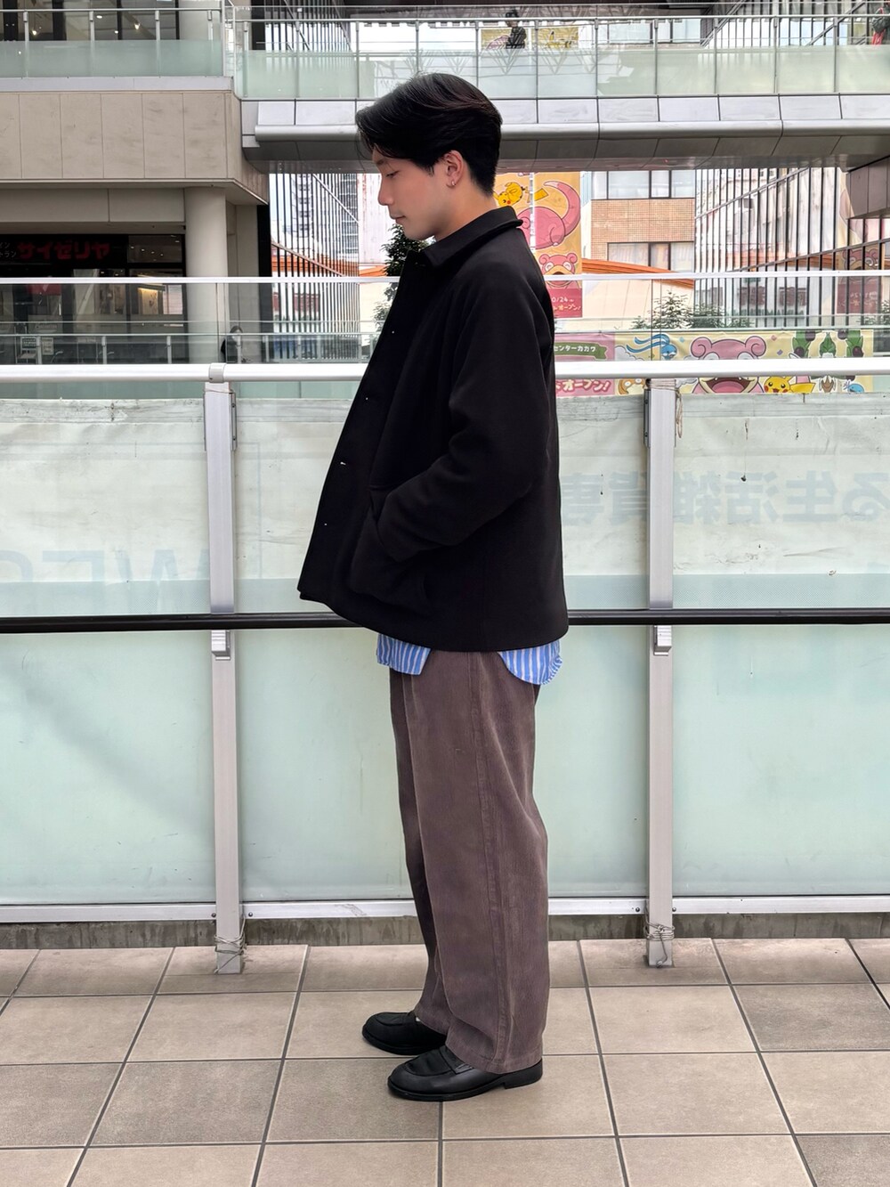 ブラック系のその他アウター、グリーン系のニット/セーター、ブラウン系のその他パンツを着用したメンズの秋コーディネートの2枚目の写真