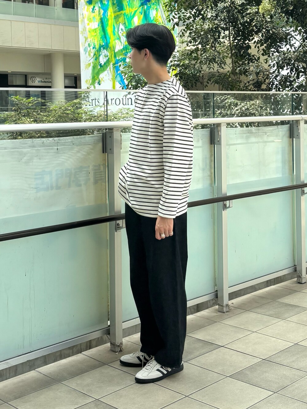 ブラック系のTシャツ/カットソー、ブラック系のデニムパンツ、ホワイト系のスニーカーを着用したメンズの秋コーディネートの2枚目の写真