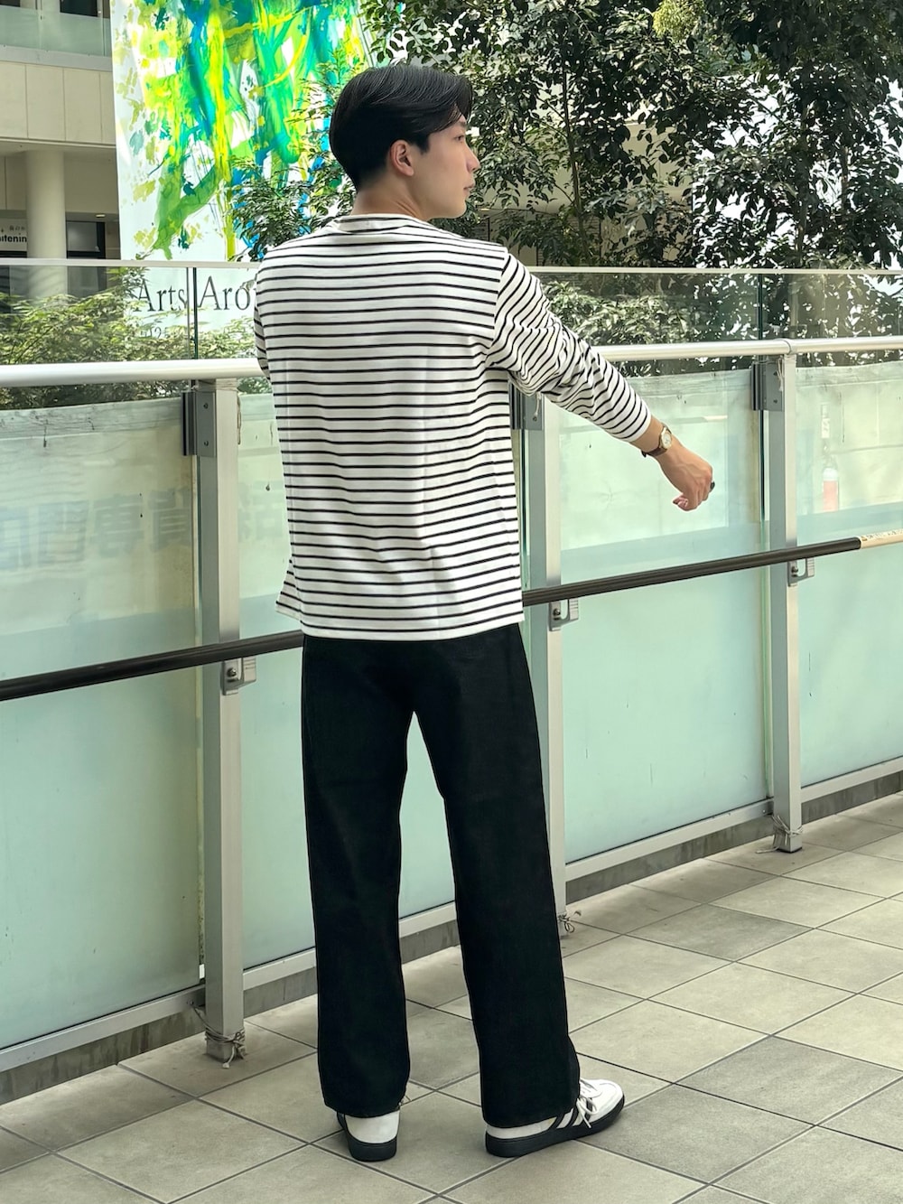 ブラック系のTシャツ/カットソー、ブラック系のデニムパンツ、ホワイト系のスニーカーを着用したメンズの秋コーディネートの3枚目の写真