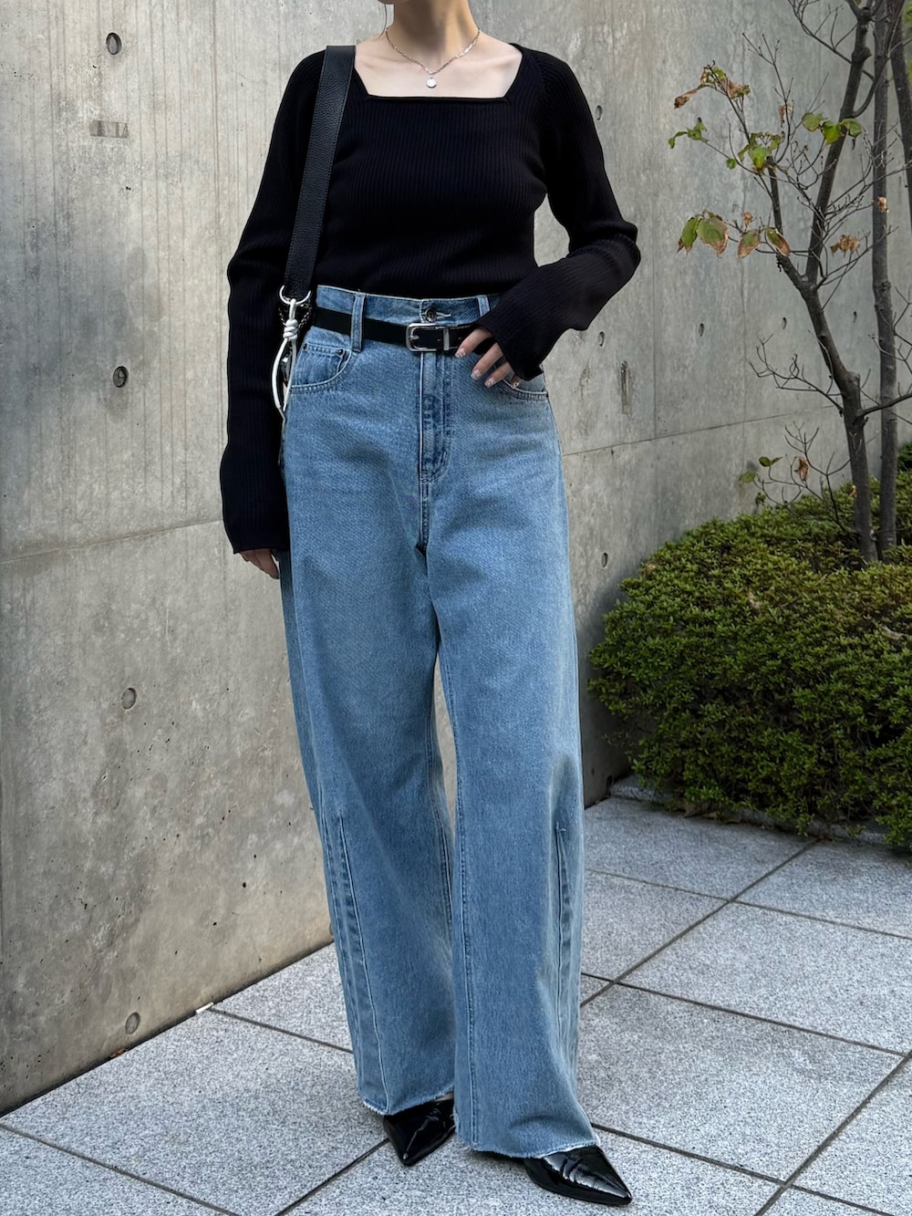 ブルー系のデニムパンツ、ブラック系のニット/セーター、ブラック系のパンプスを着用したレディースの秋コーディネートの2枚目の写真