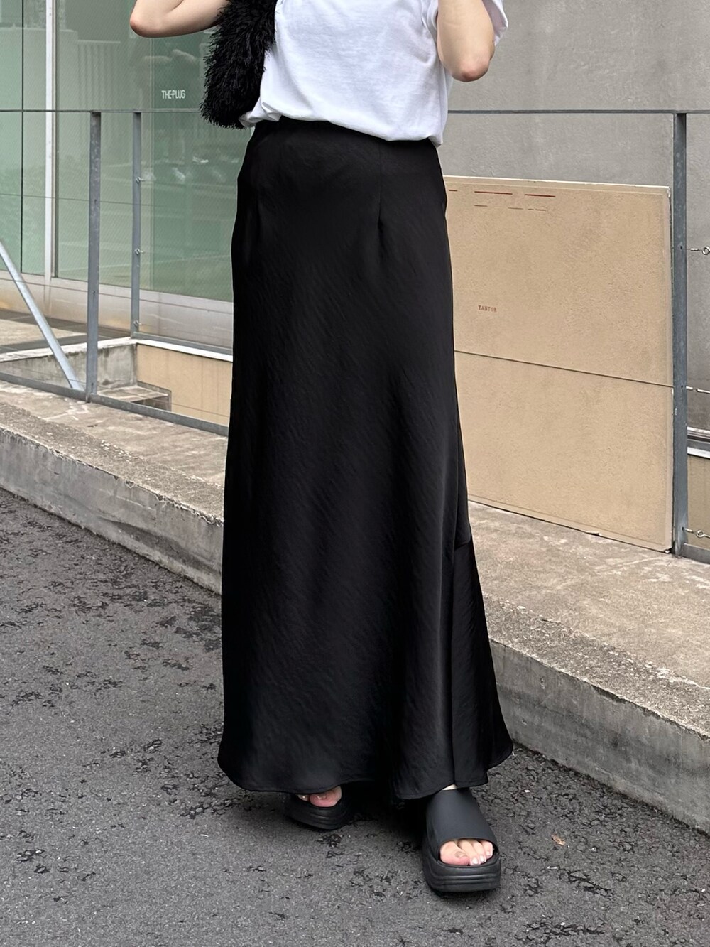 ホワイト系のTシャツ/カットソー、ブラック系のバッグ、ブラック系のスカートを着用したレディースの夏コーディネートの5枚目の写真