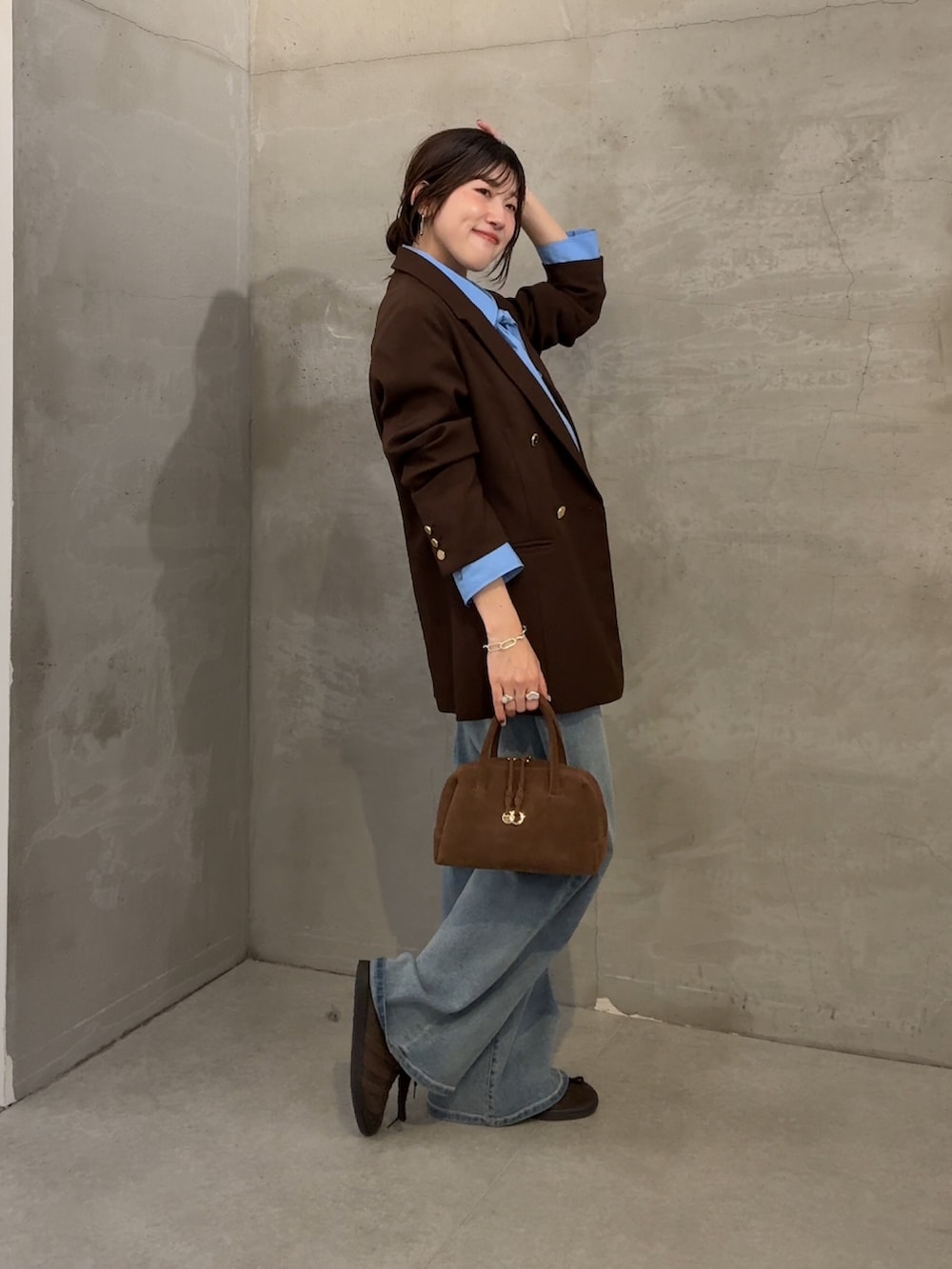 ブラウン系のテーラードジャケット、ブルー系のシャツ/ブラウス、ブルー系のデニムパンツを着用したレディースの秋コーディネートの2枚目の写真