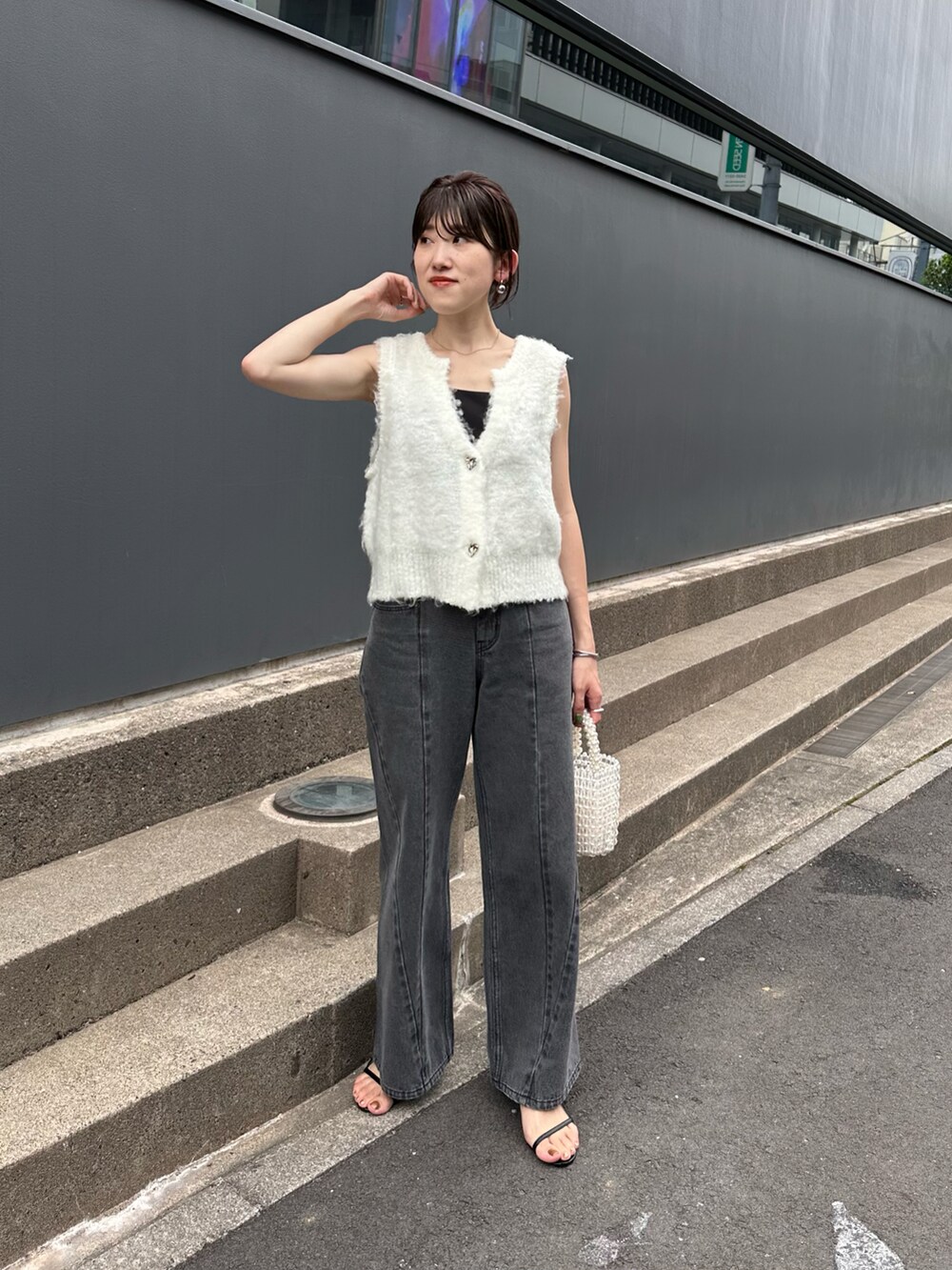 ホワイト系のカーディガン/ボレロ、ブラック系のキャミソール、ブルー系のデニムパンツを着用したレディースの夏コーディネートの5枚目の写真