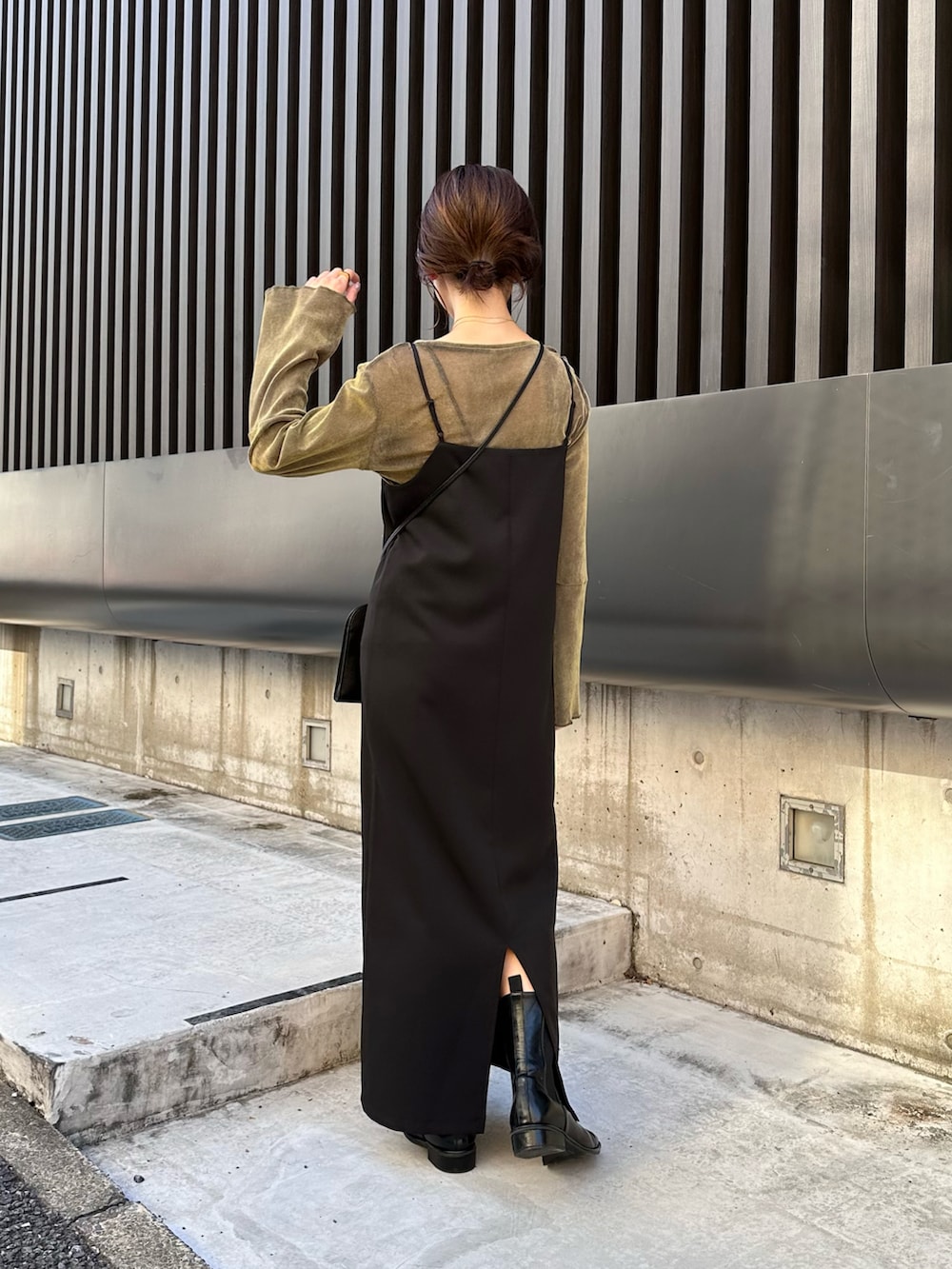 ブラック系のワンピース、グリーン系のTシャツ/カットソー、ブラック系のブーツを着用したレディースの秋コーディネートの2枚目の写真